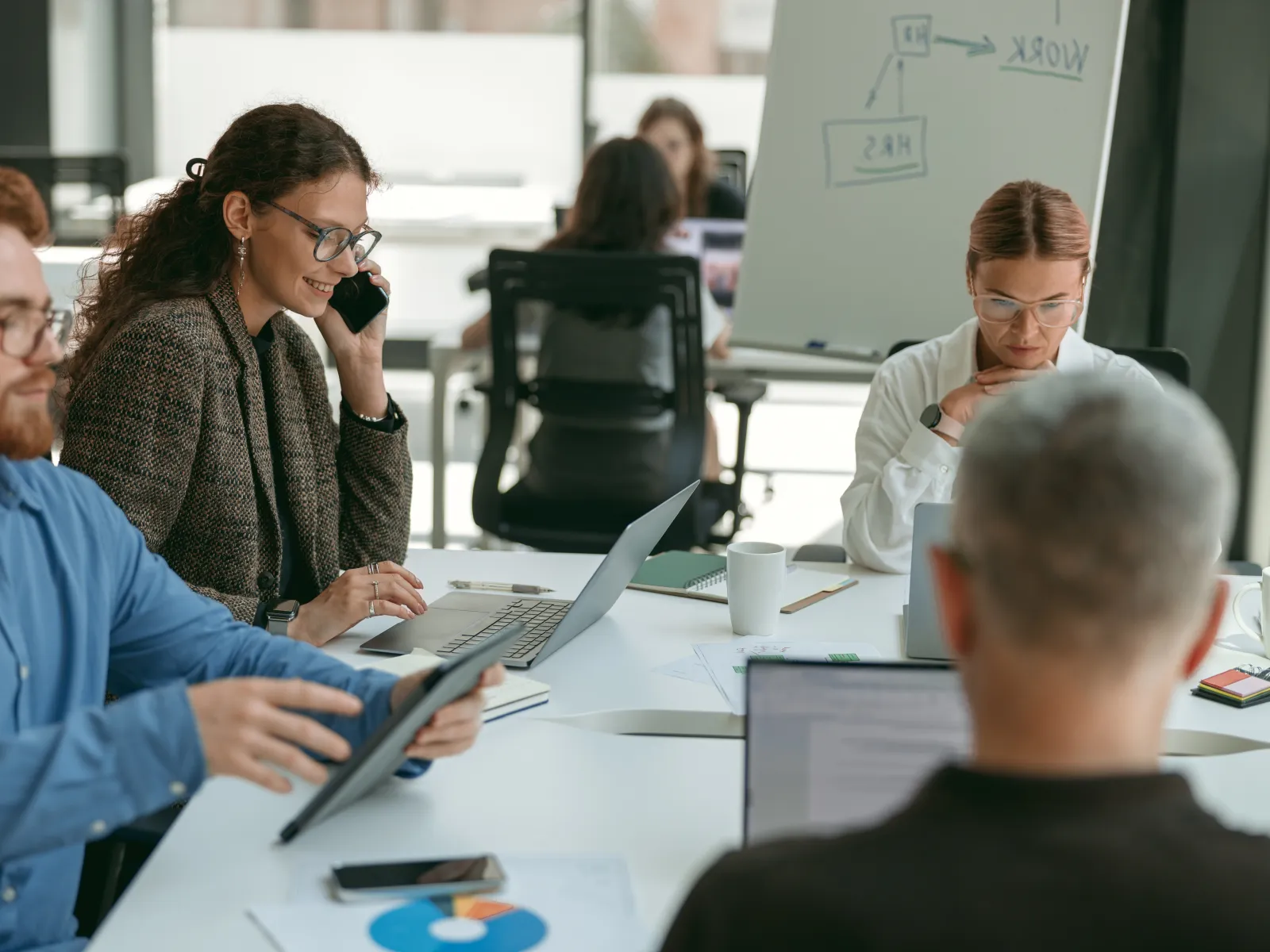 a group of people sitting around a table looking at a laptop