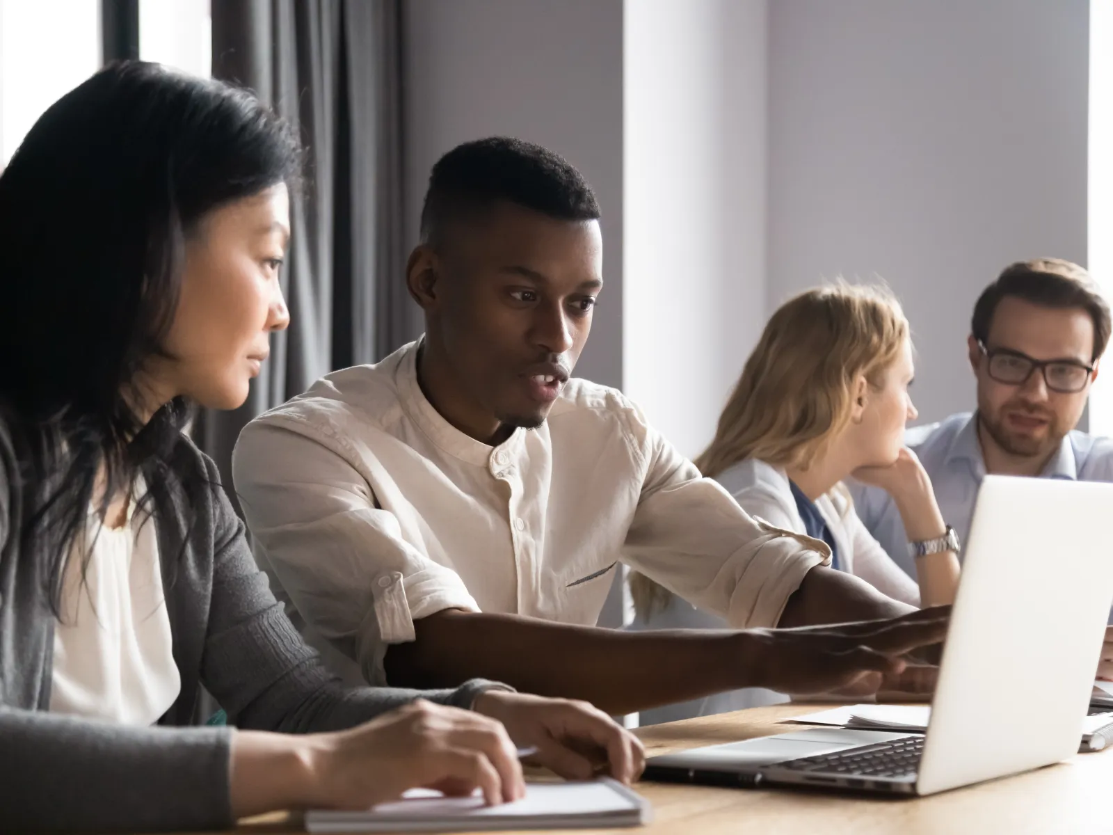 a group of people looking at a laptop