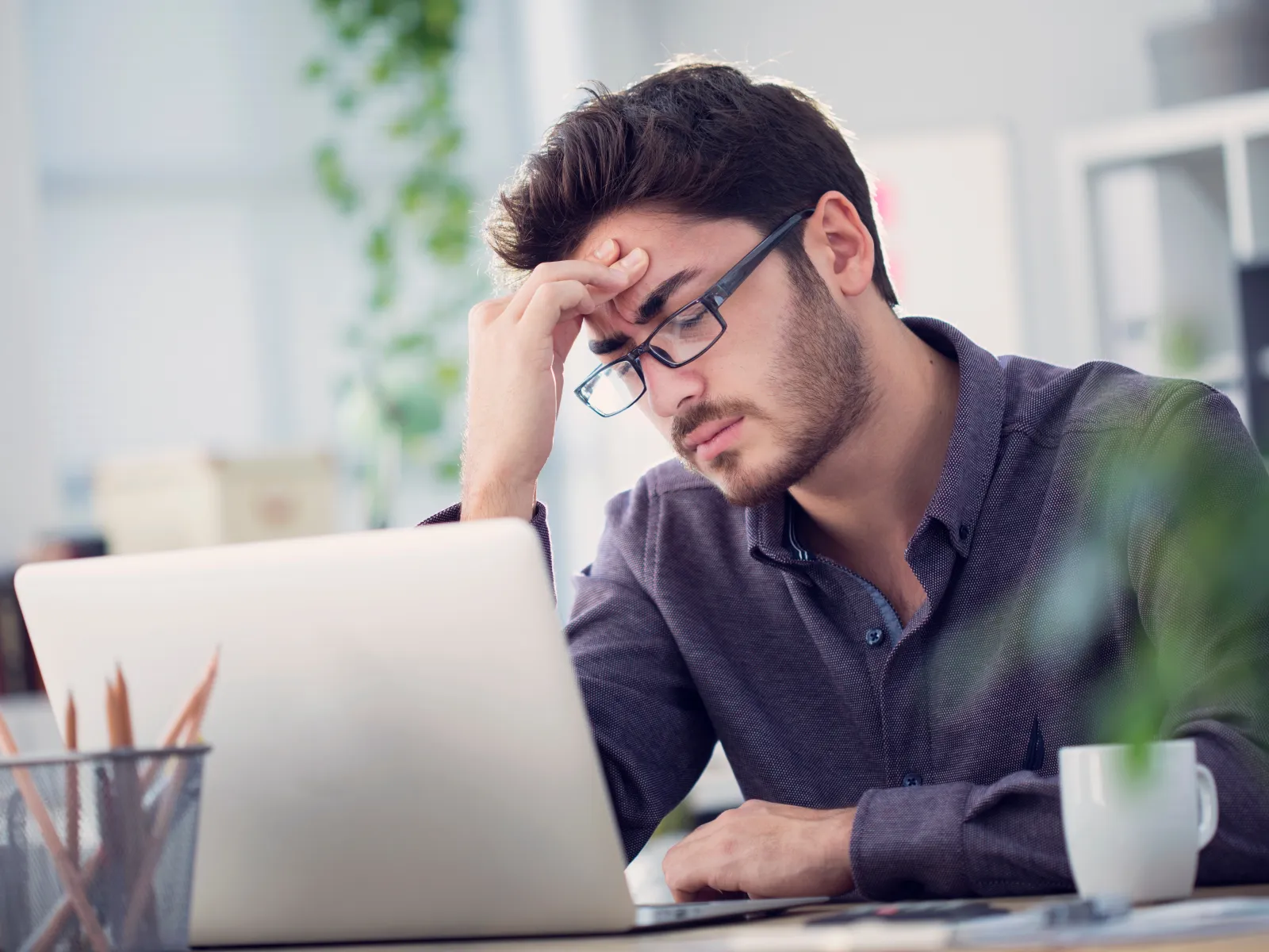 a man with headphones on looking at a laptop
