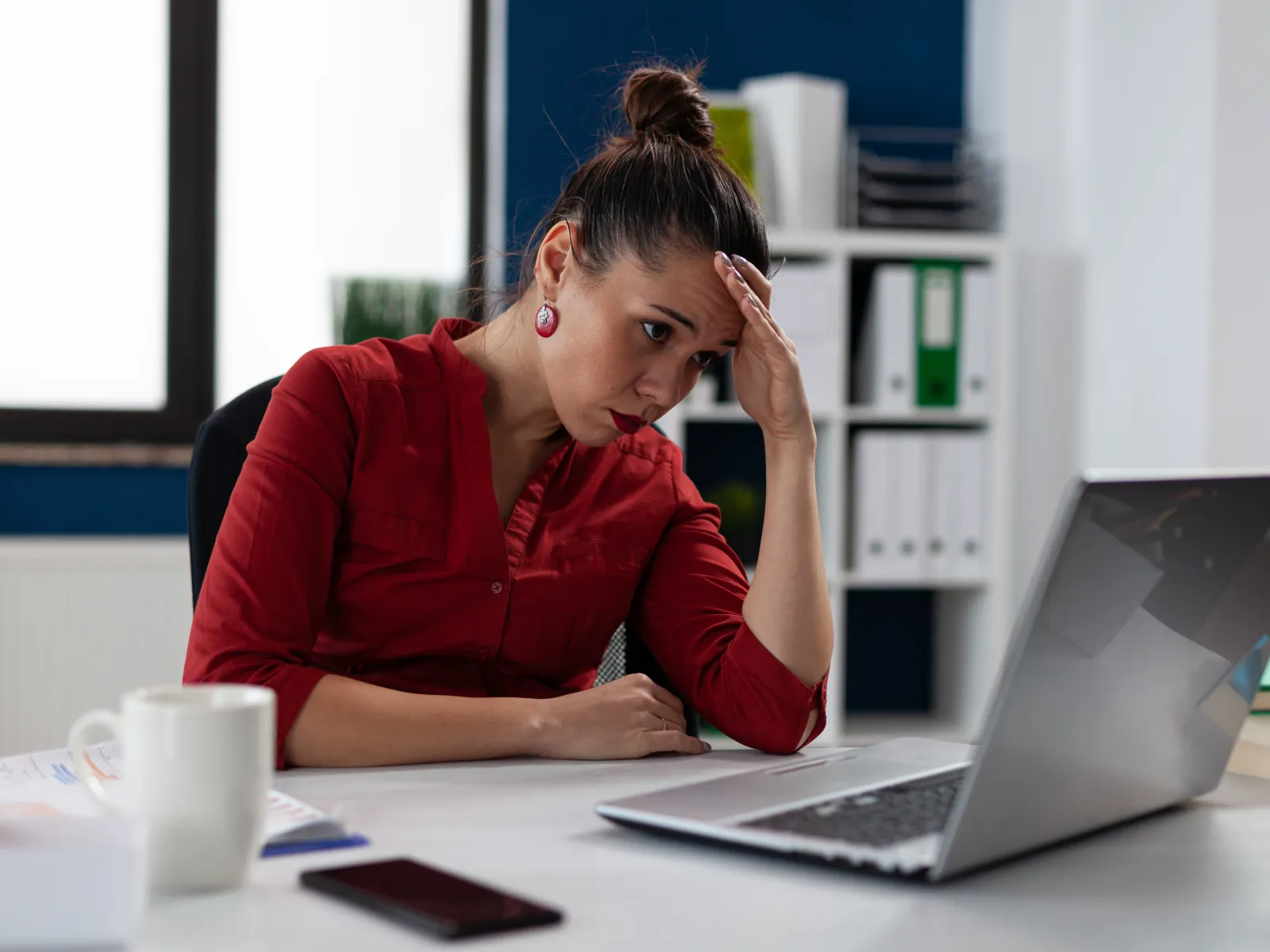 a woman sitting at a desk with a laptop