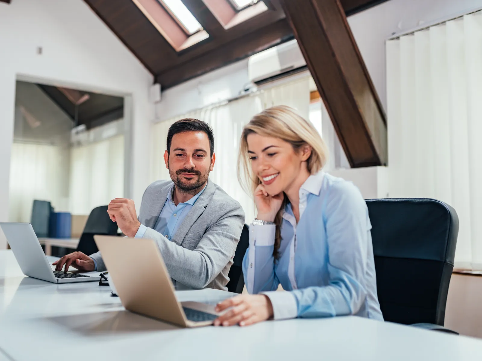 a man and a woman looking at a laptop