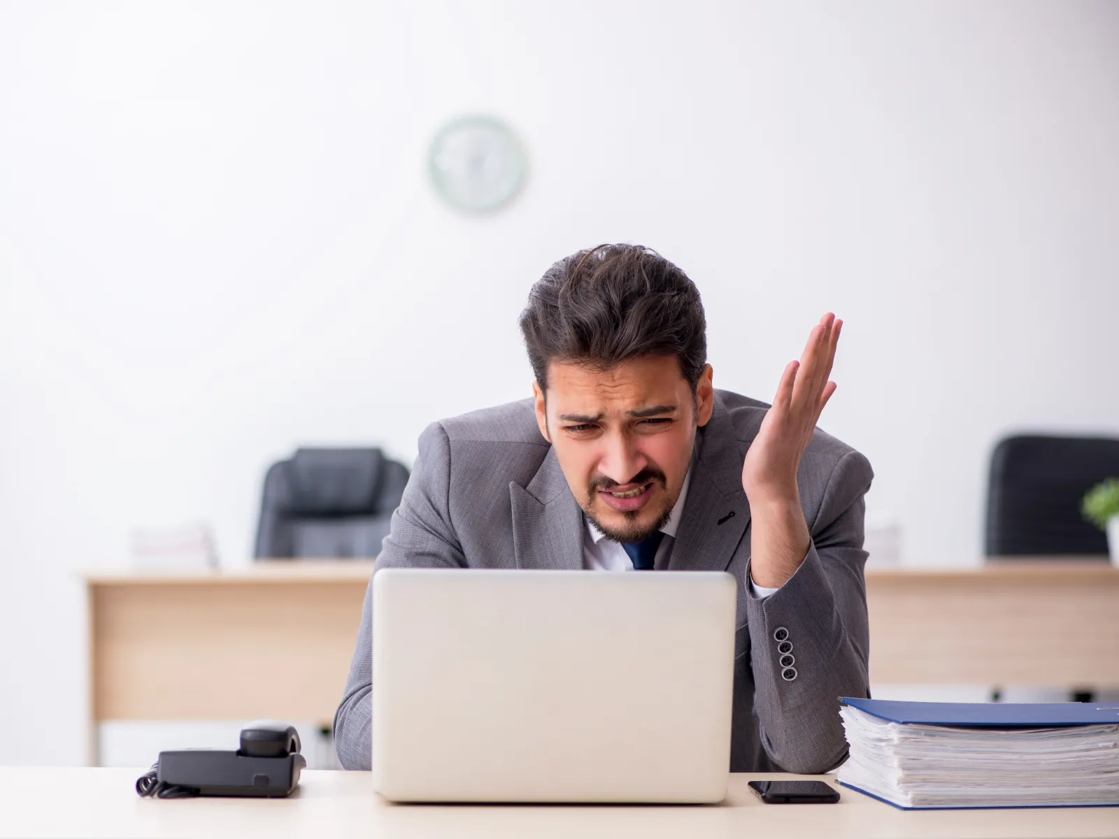 a person sitting at a desk with the hand up