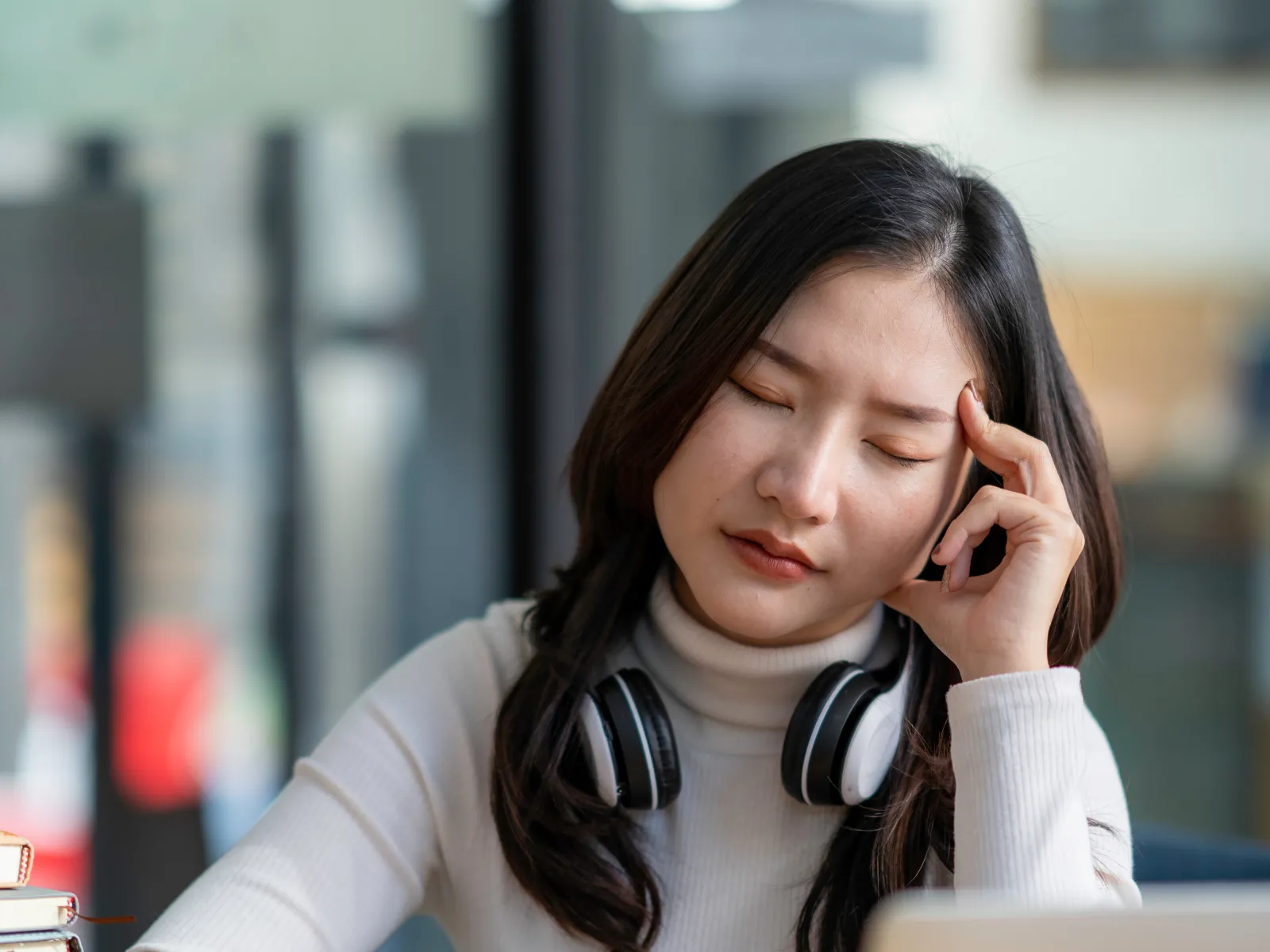 a woman with headphones on looking at a laptop