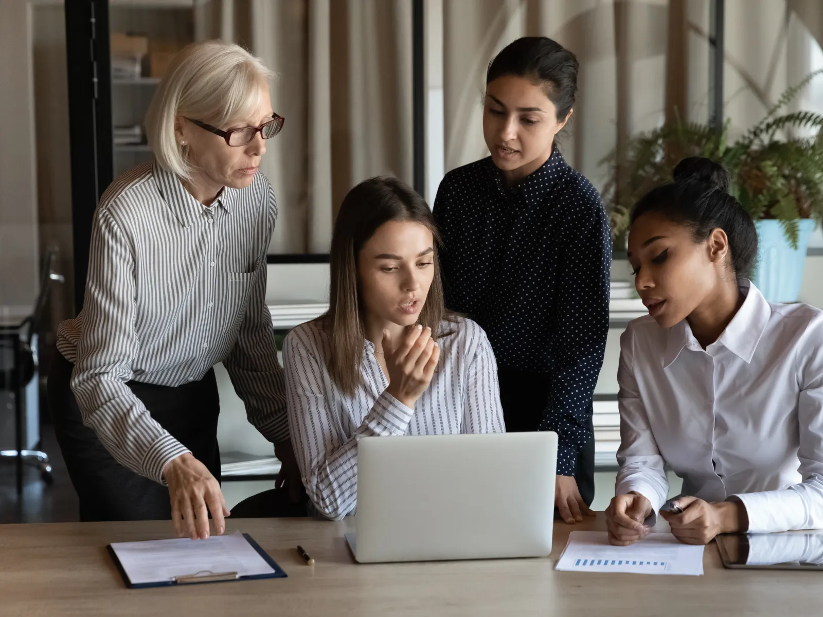 a group of people looking at a laptop