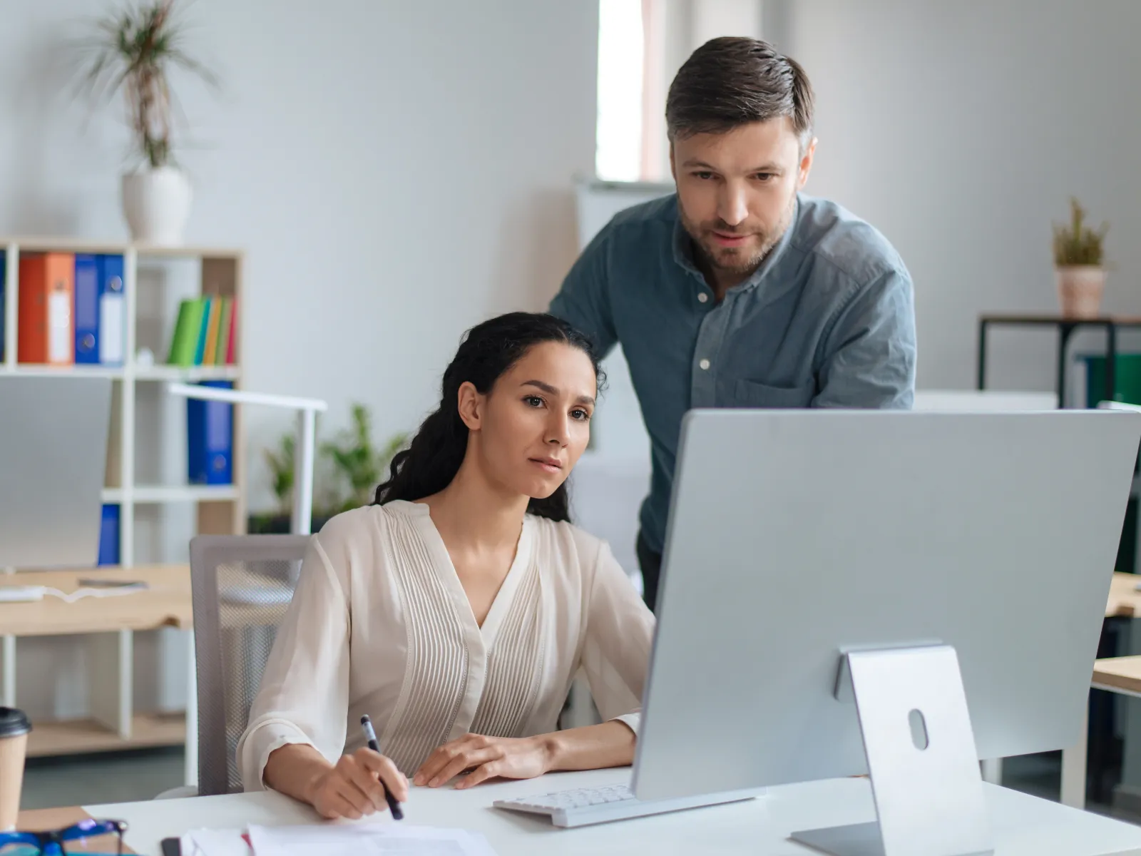 a man and a woman looking at a computer screen