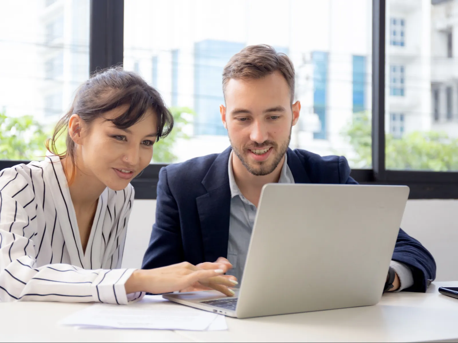 a man and a woman looking at a laptop