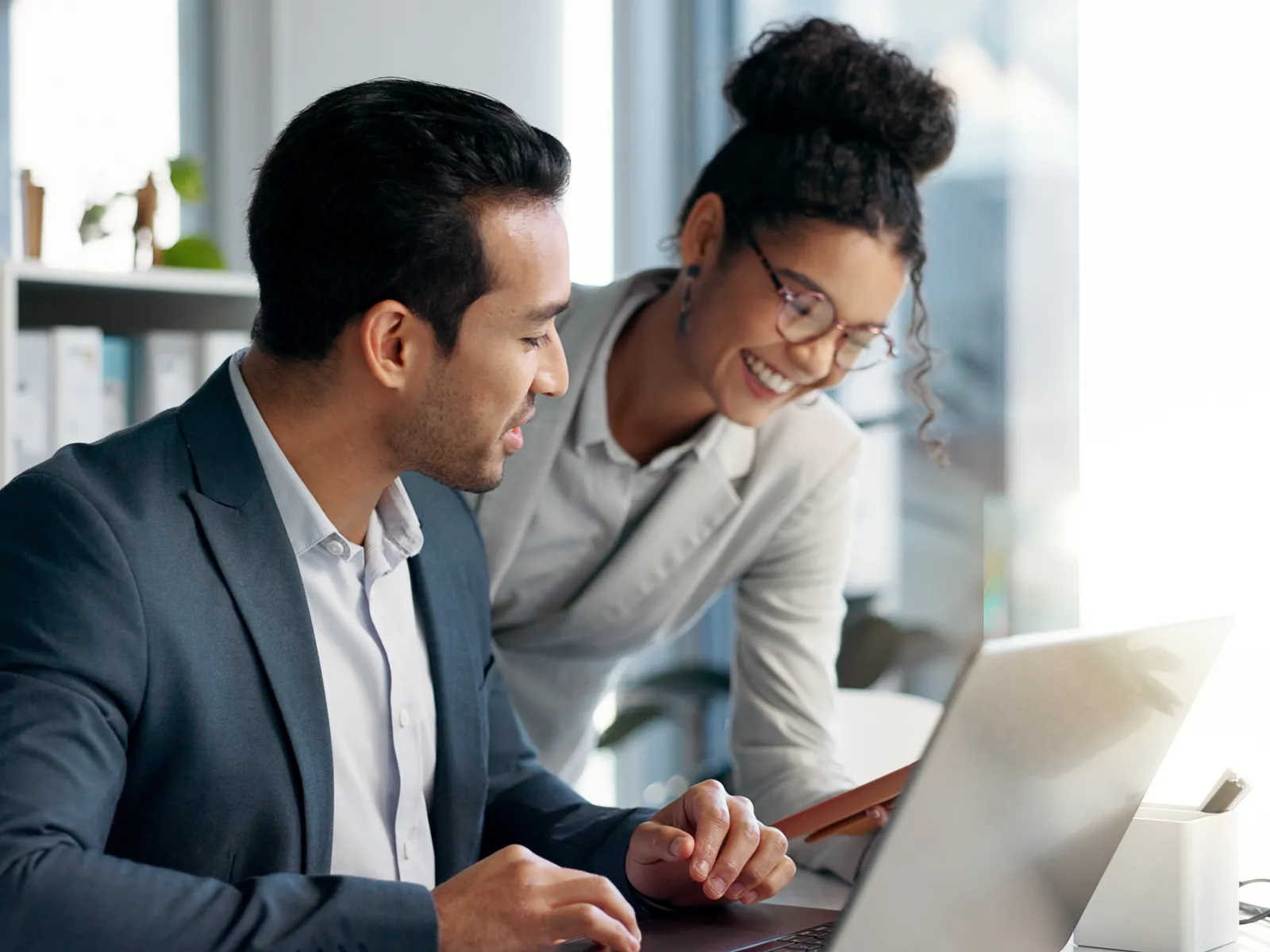 a man and a woman looking at a laptop