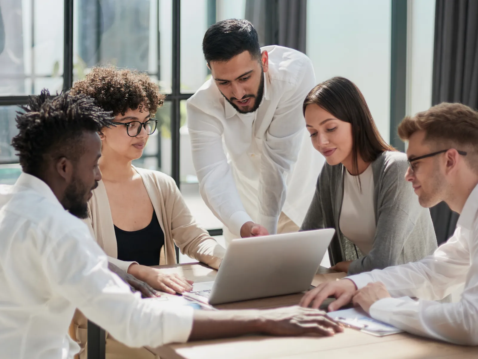 a group of people looking at a laptop