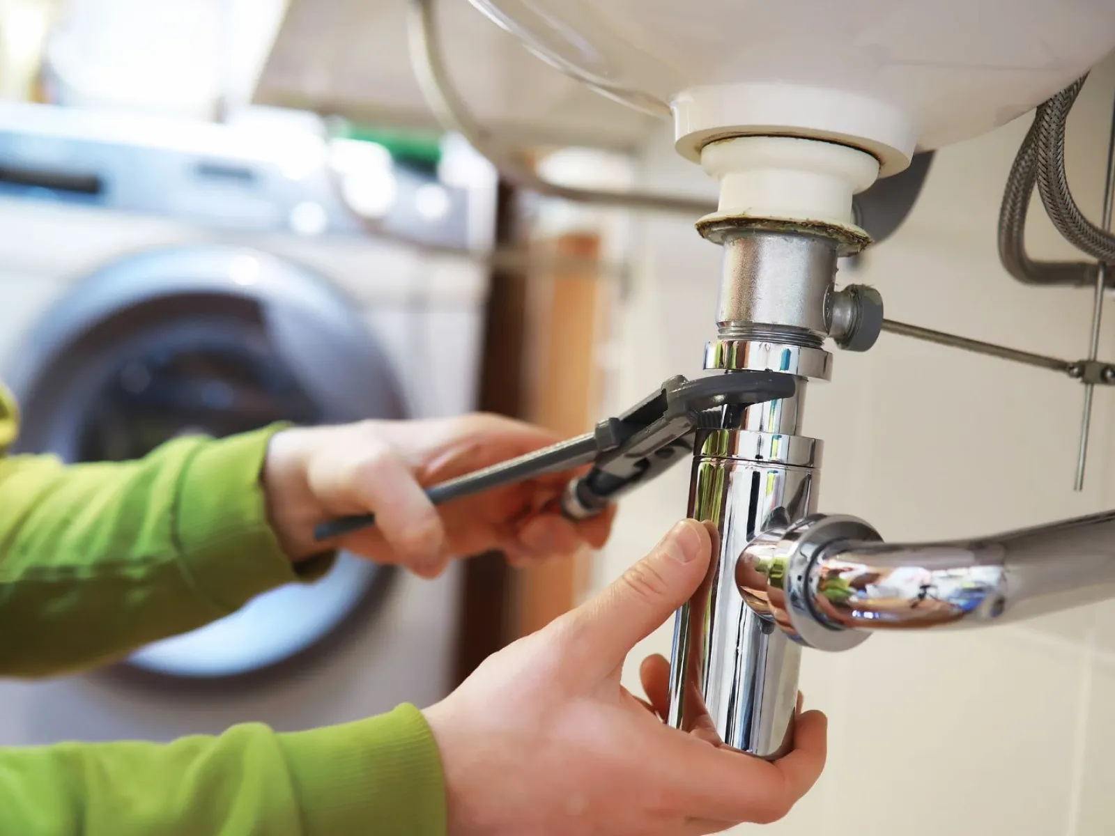 a person washing a faucet