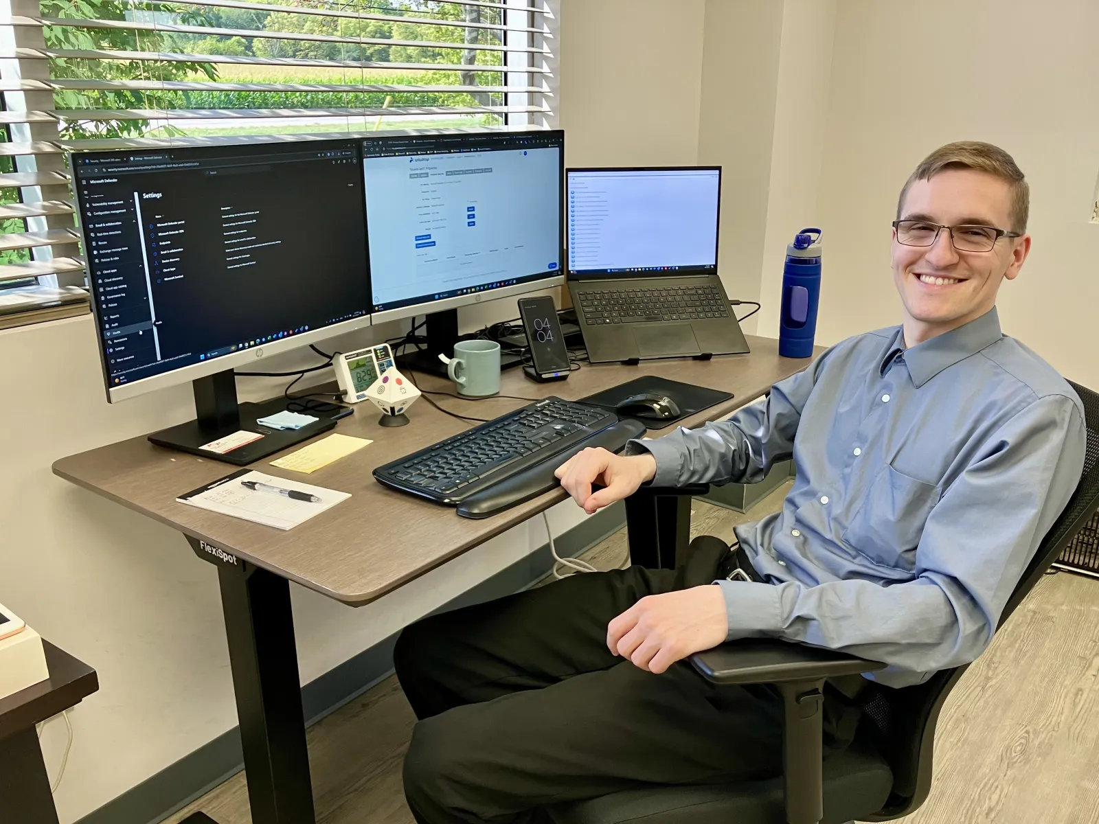 a man sitting at a desk with a computer and other computers