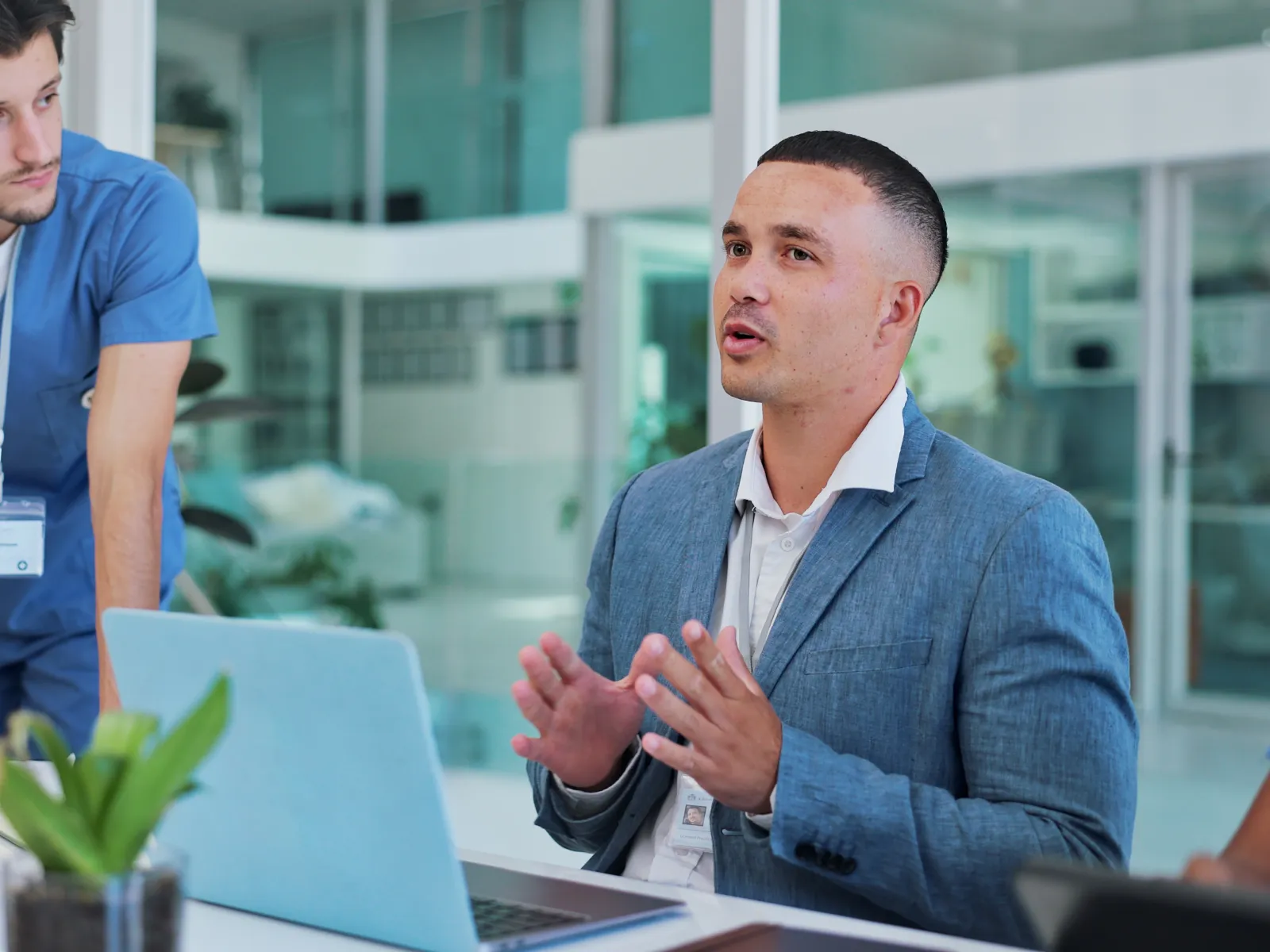 Business professional in blue suit discussing ideas with healthcare workers in medical office meeting