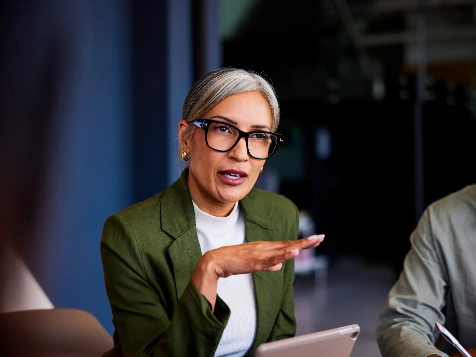 Three diverse business colleagues collaborating on a project using a laptop in a modern office.