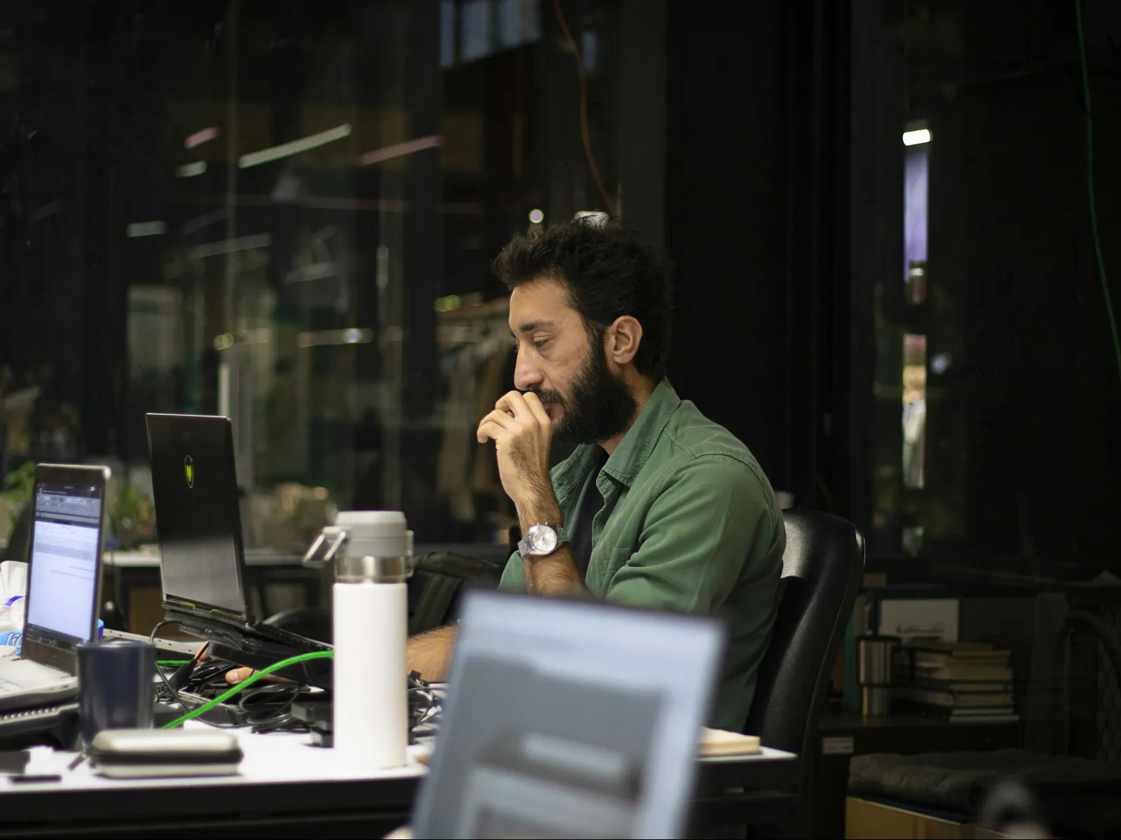 a person sitting at a desk with a laptop and a microphone