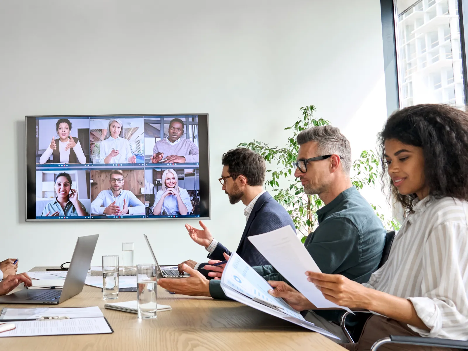 a group of people sitting around a table looking at a screen