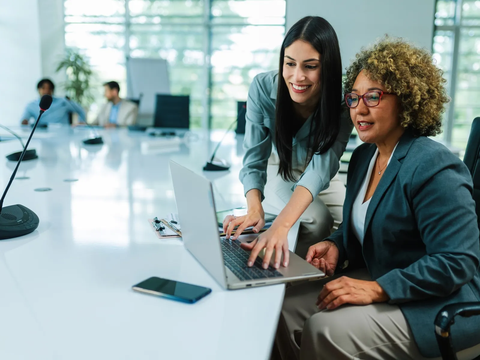 a couple of women sitting at a table with a laptop