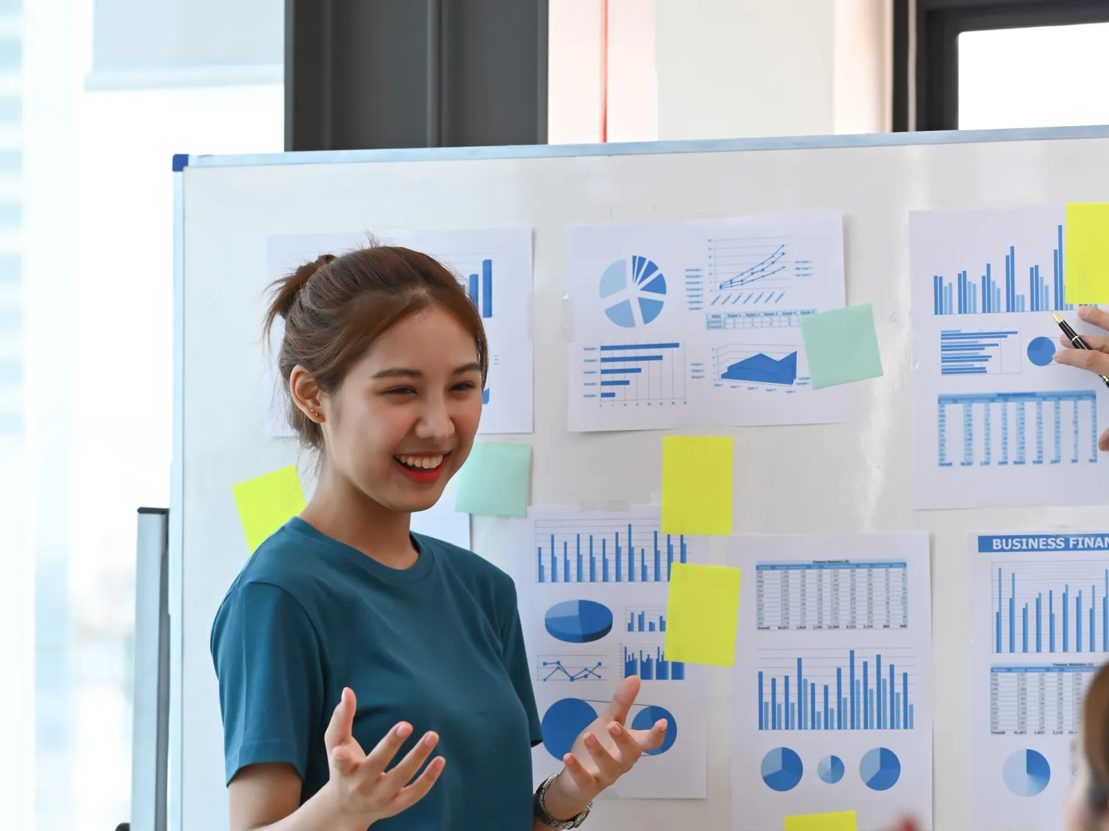 a person standing in front of a white board with colorful stickers