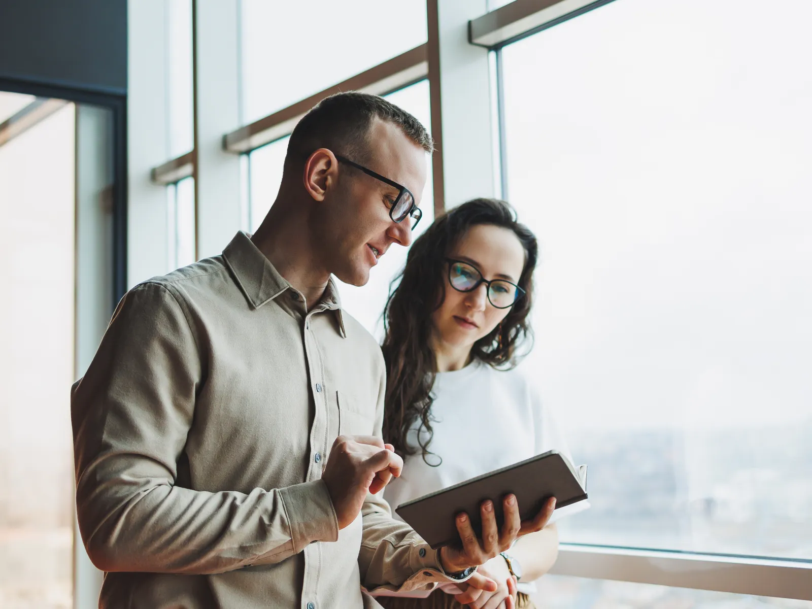 a man and woman looking at a book