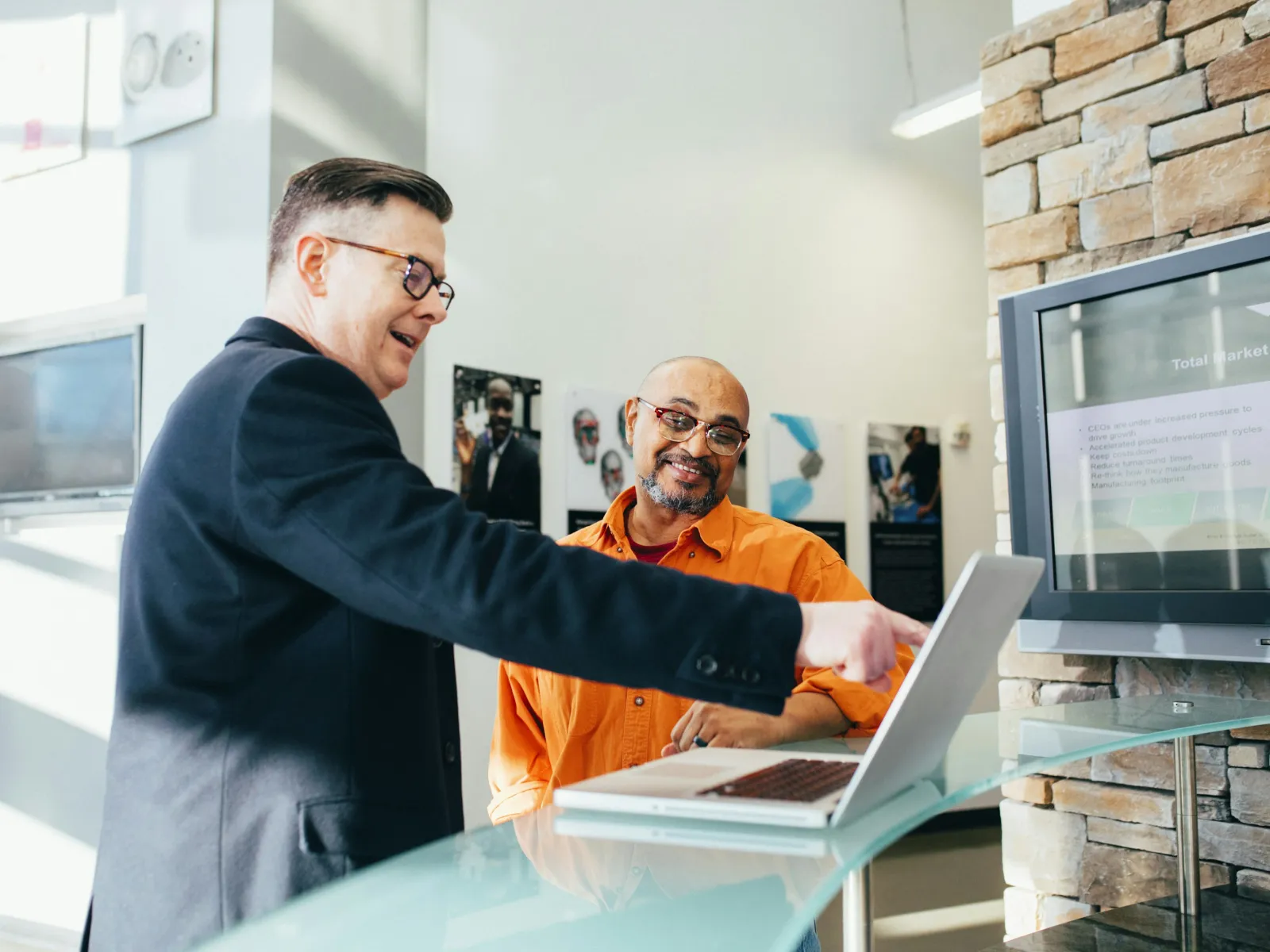 a man showing a man something on the laptop