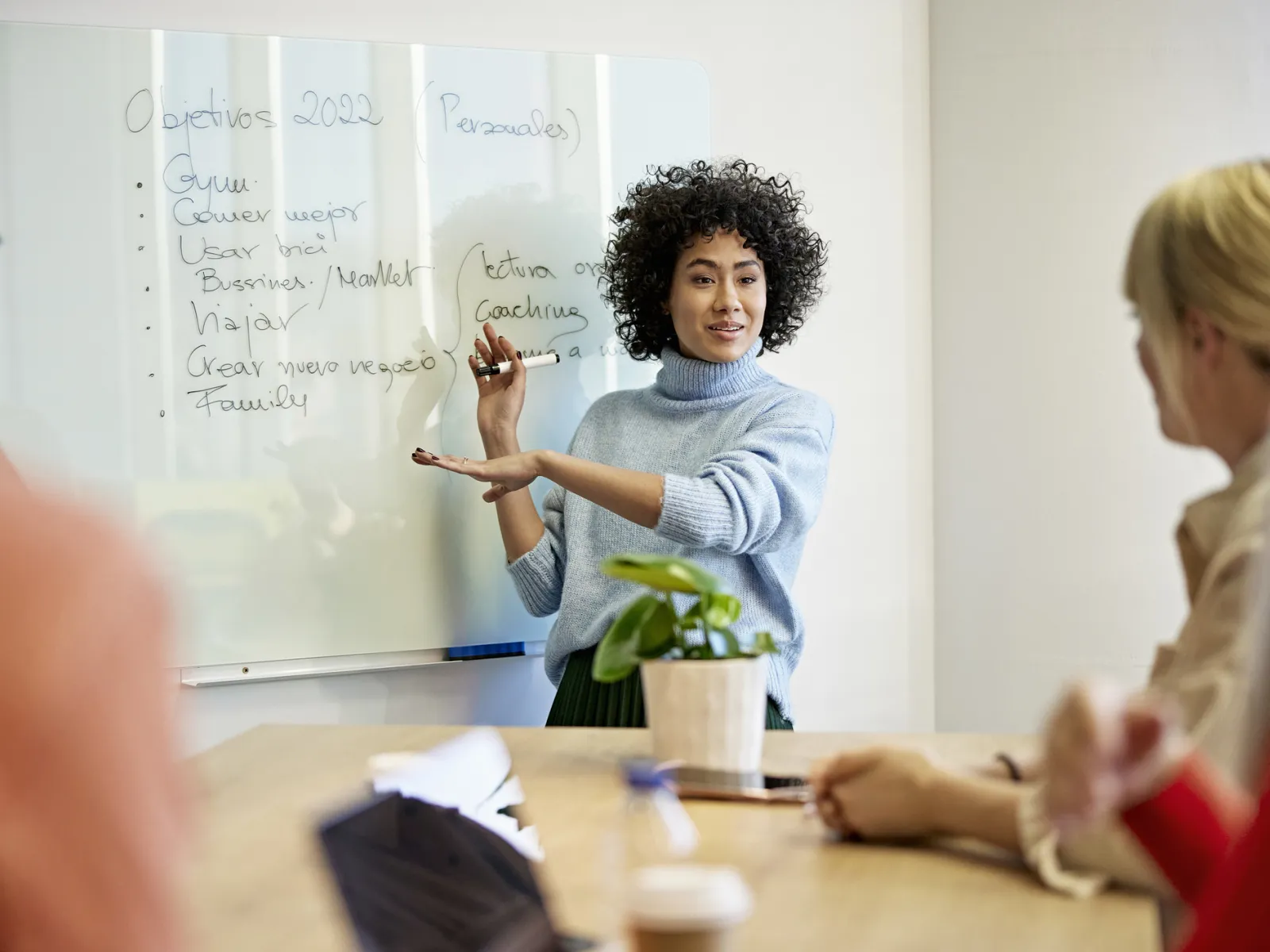 a woman writing on a whiteboard