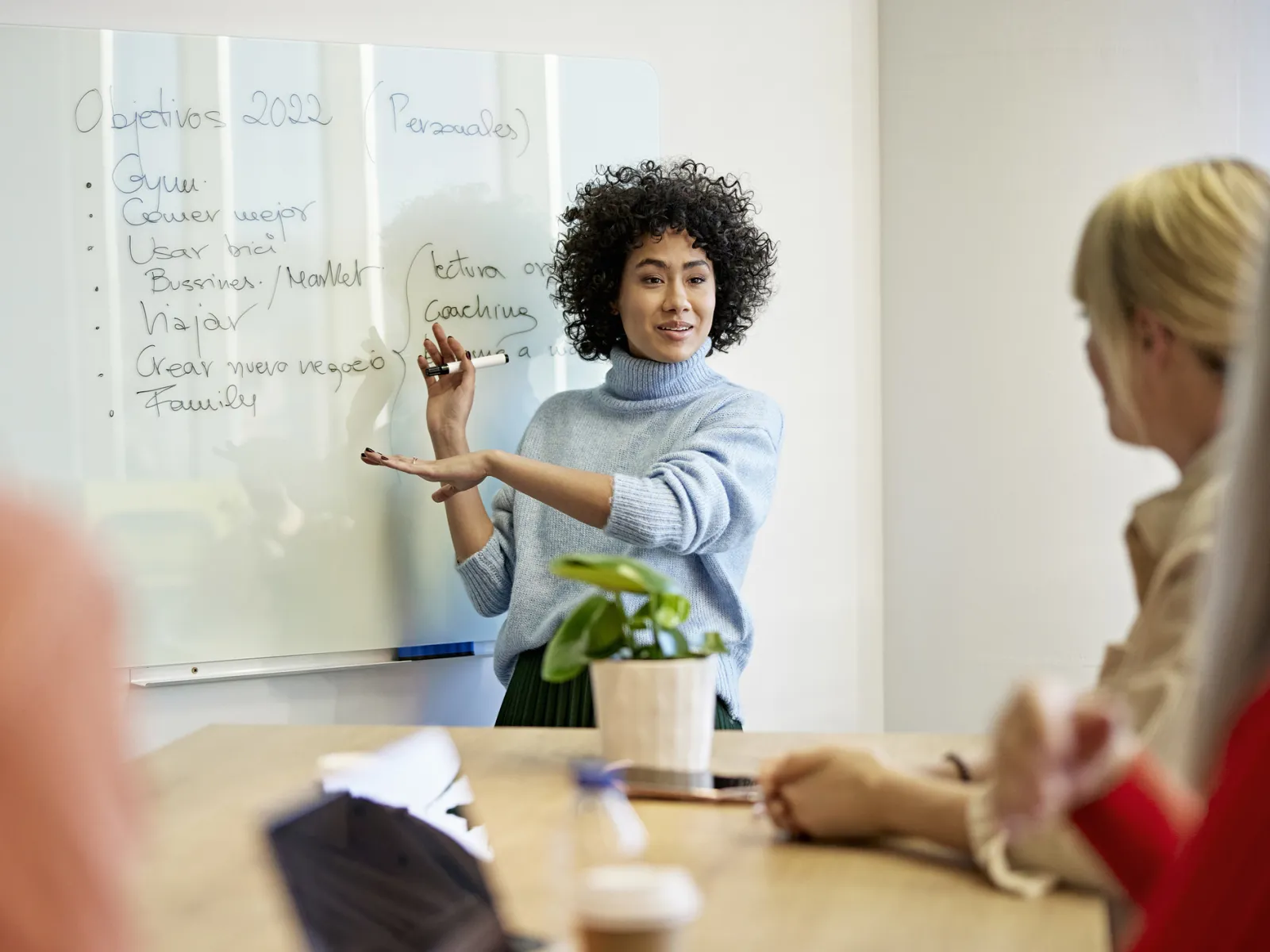a woman writing on a whiteboard