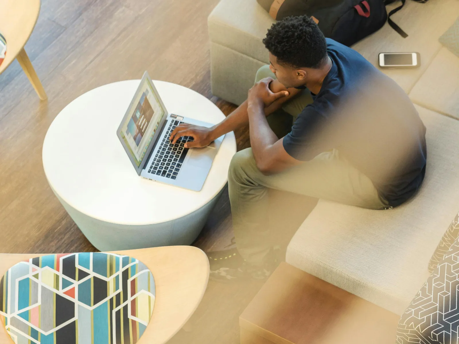 a person sitting on a couch using a laptop