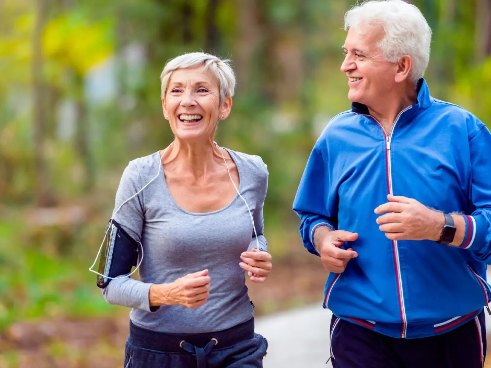 an adult couple running together on a trail