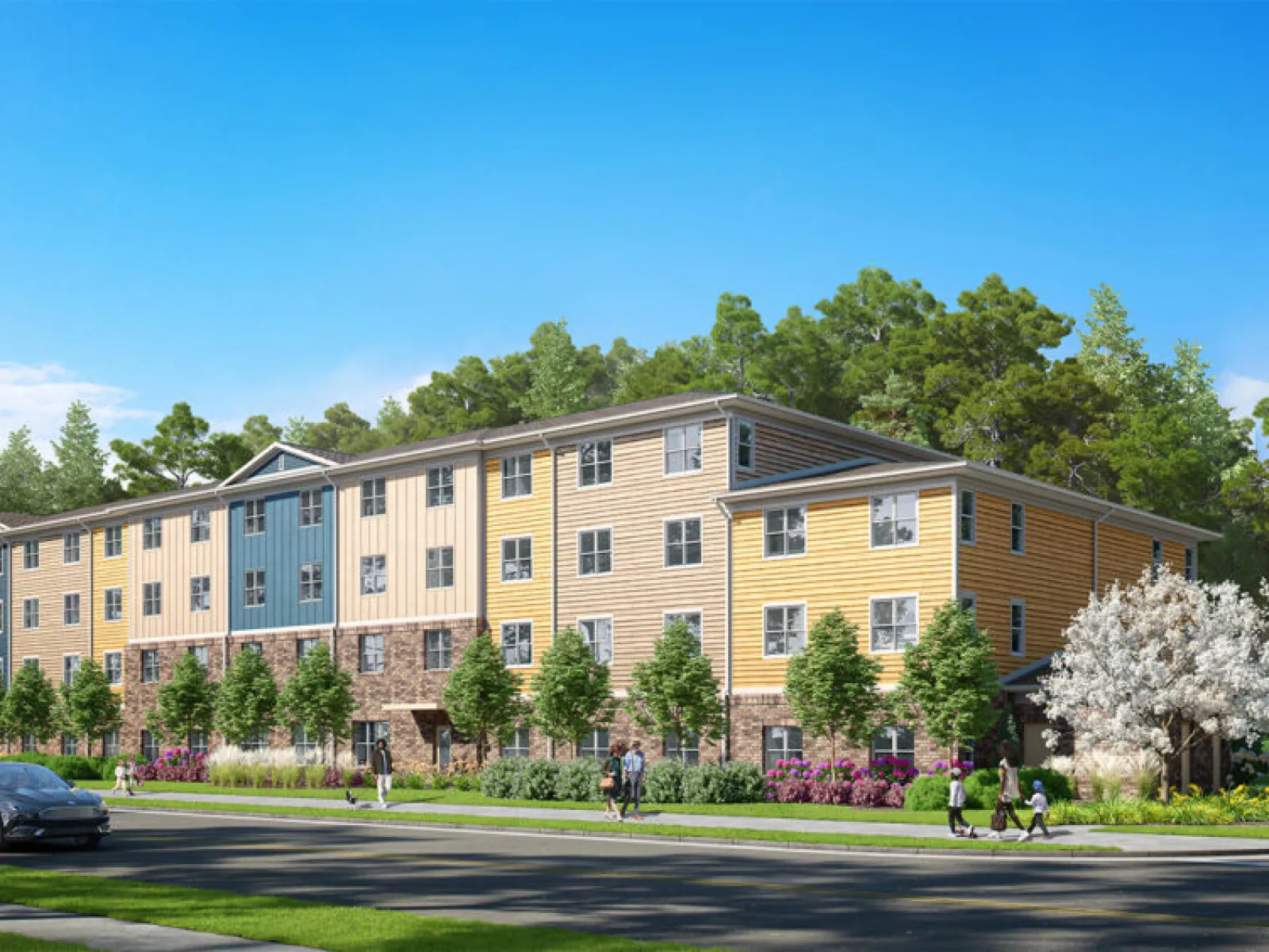 Modern four-story apartment building surrounded by trees, greenery, and people walking on a sunny day.