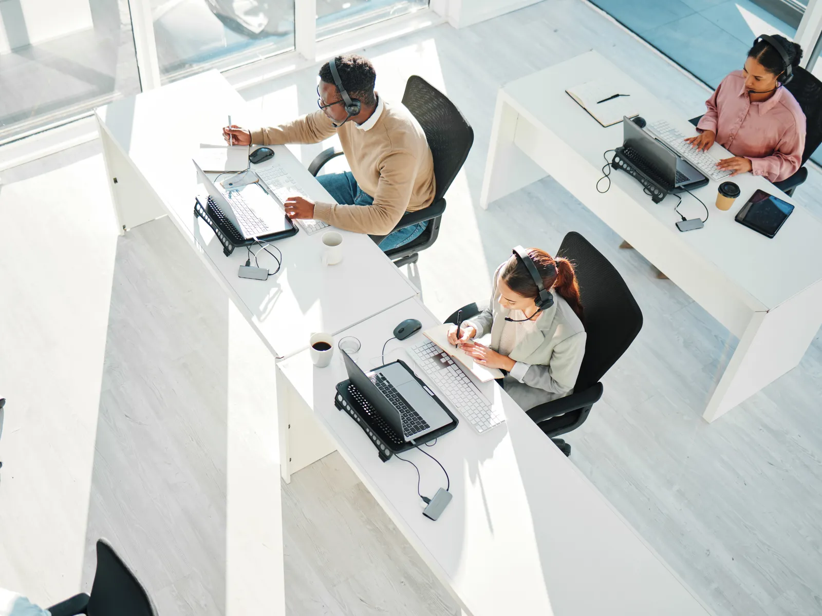 a group of people sitting at a table with computers