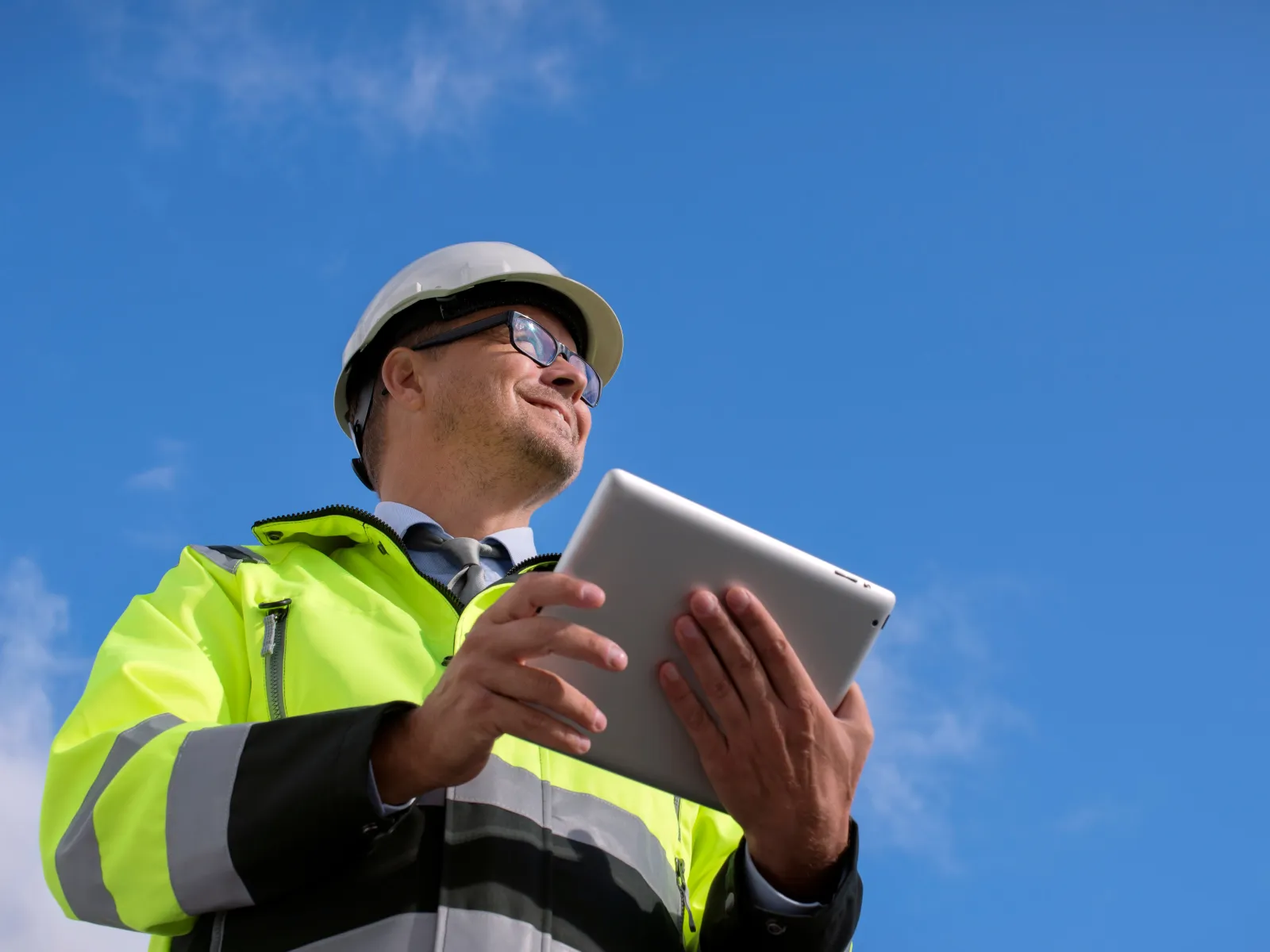 a man in a yellow vest reading a book