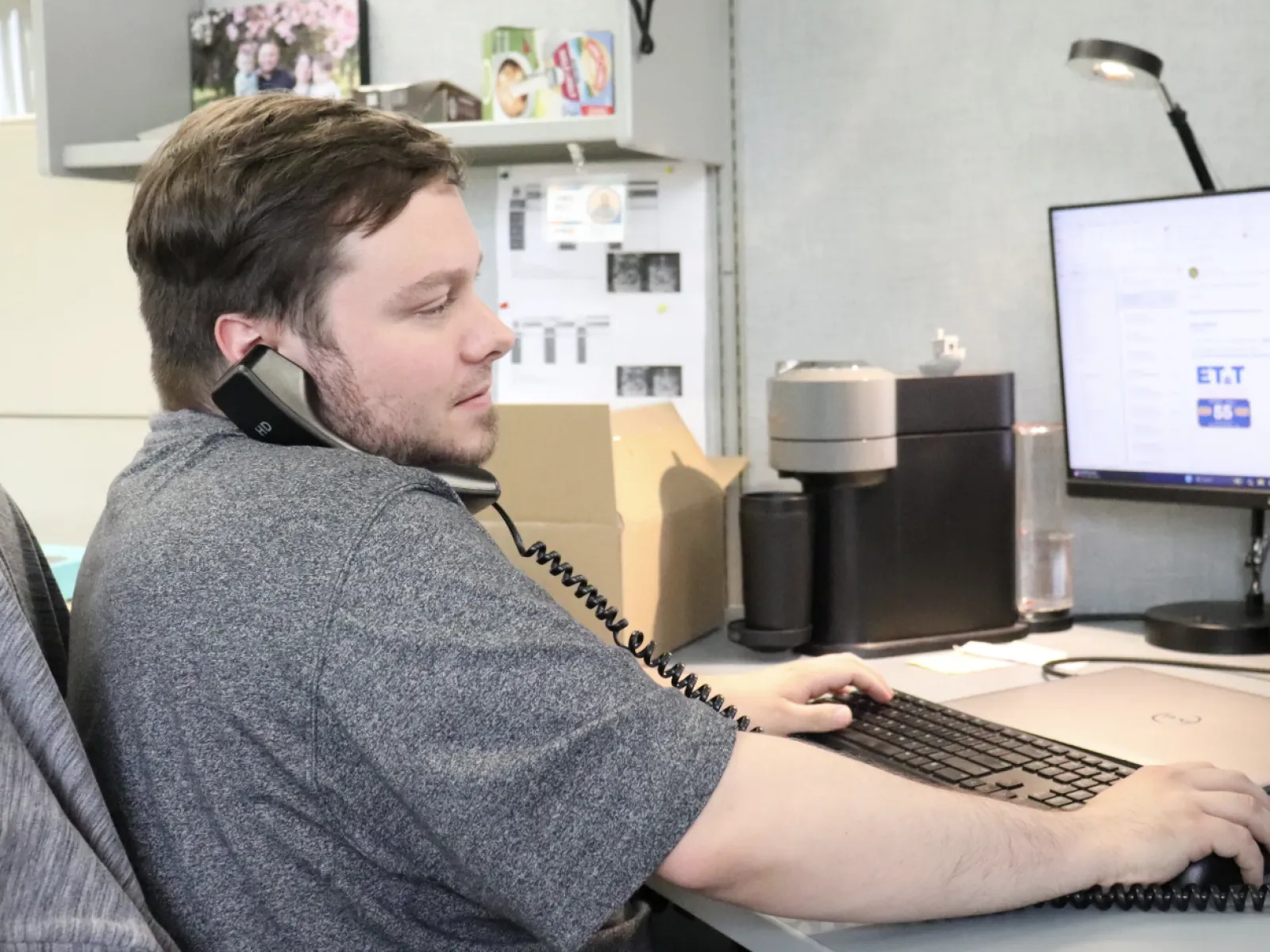 a person sitting at a desk with a computer and headphones on