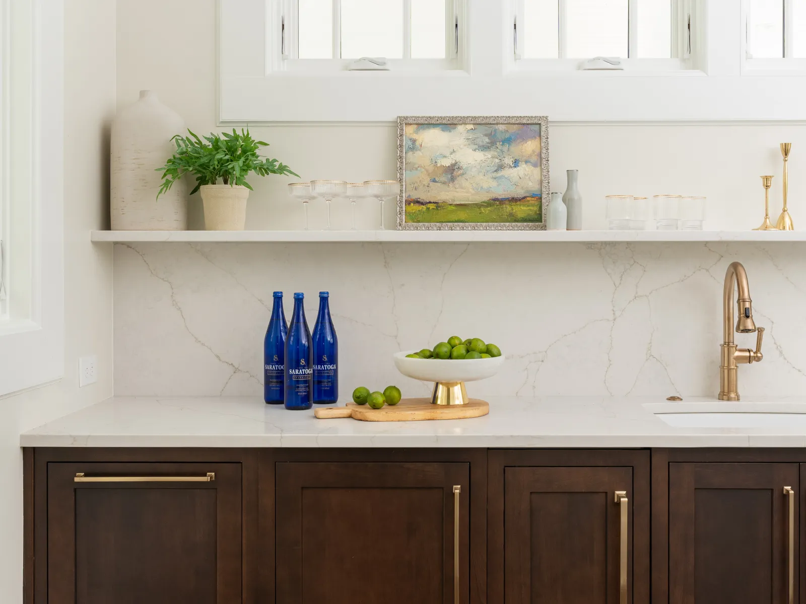 Elegant kitchen cabinetry with a marble countertop, decorative elements, and green accents.