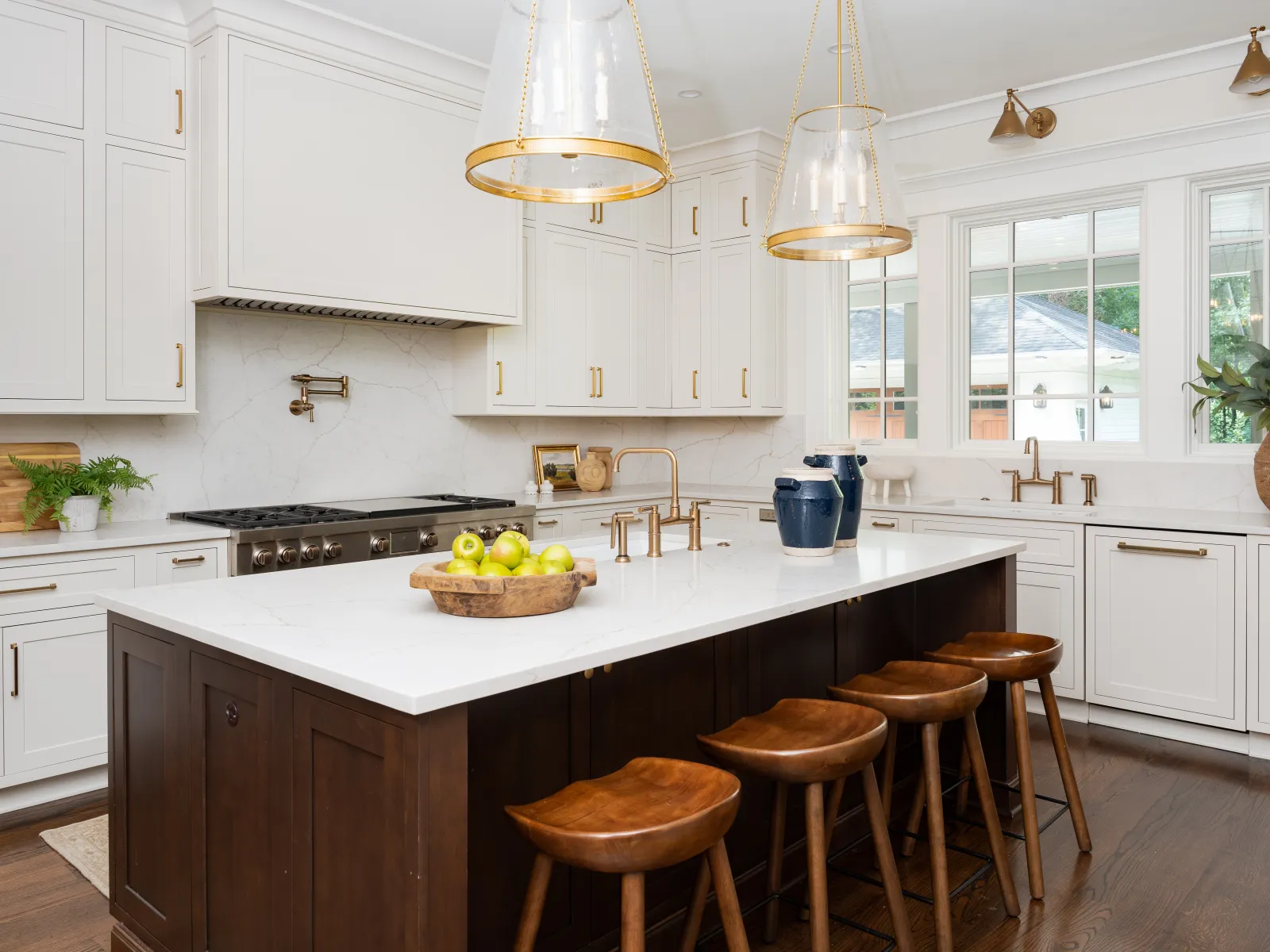 Modern kitchen with white cabinets, elegant island, and warm wooden accents, bright and inviting atmosphere.