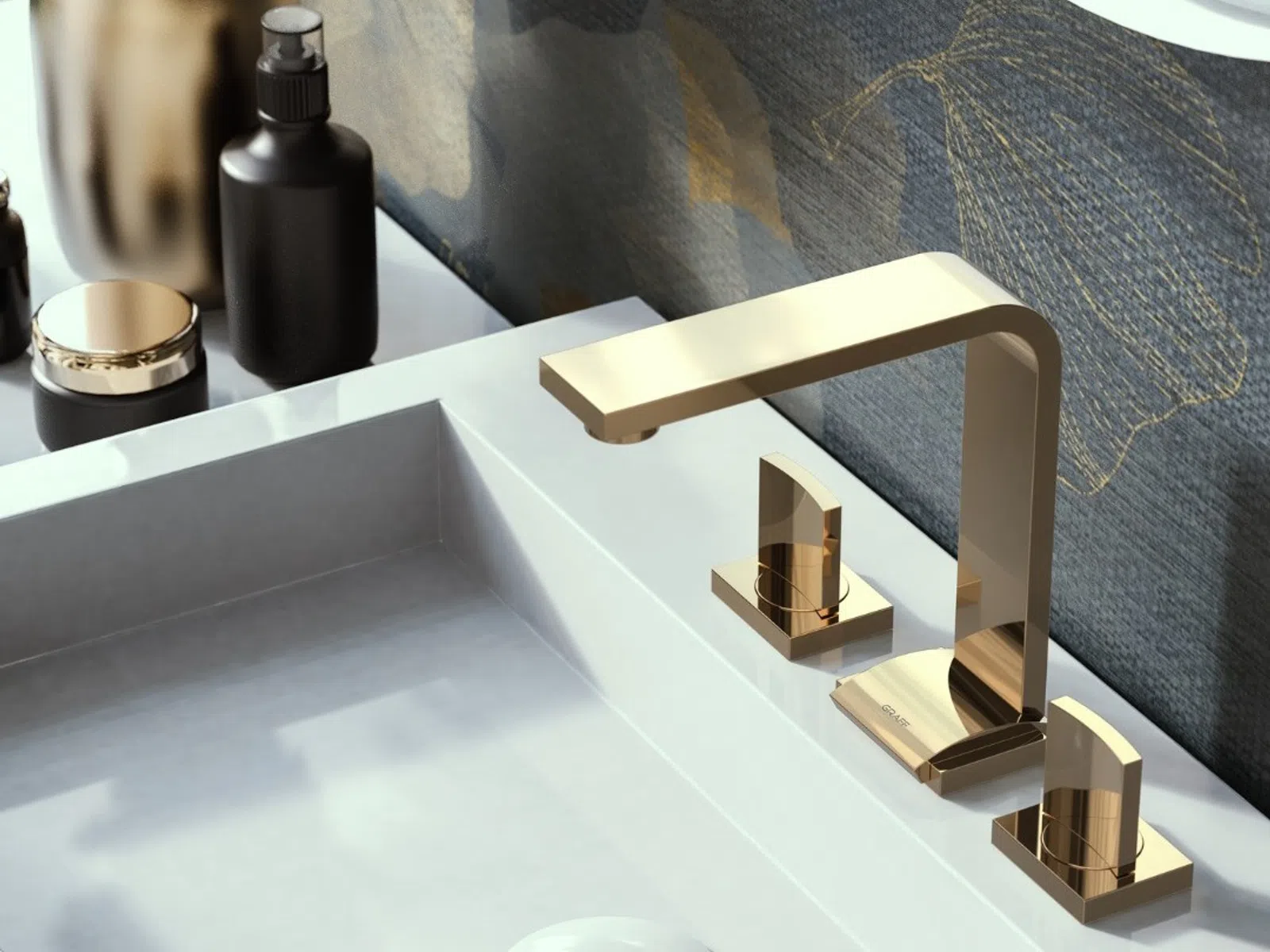 Modern bathroom sink with sleek gold faucet and black toiletry bottles on white countertop.