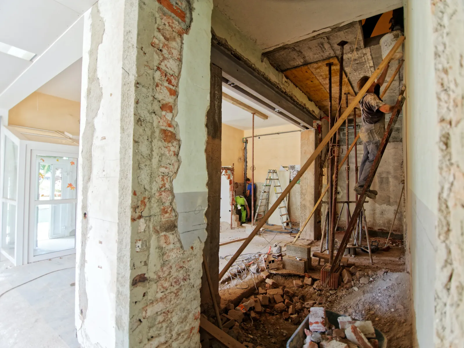 a person standing on a ladder in a room with debris all over