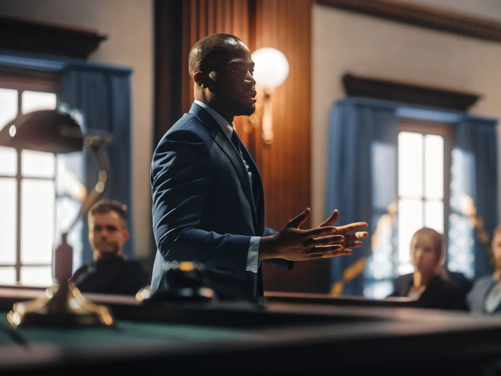 Confident lawyer presenting a case in courtroom with attentive jurors in background during trial session