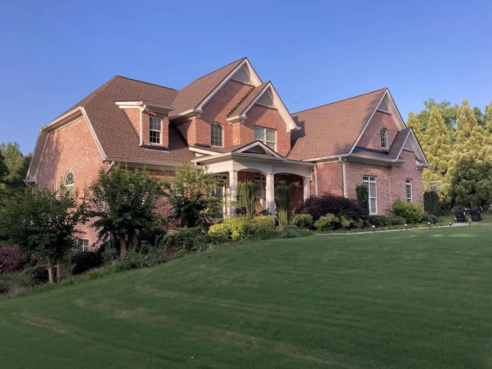 a large brick house with a lawn in front of it