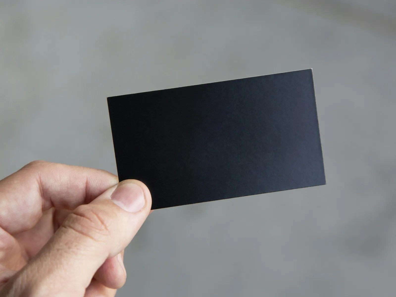 a hand holding a black square with a white background