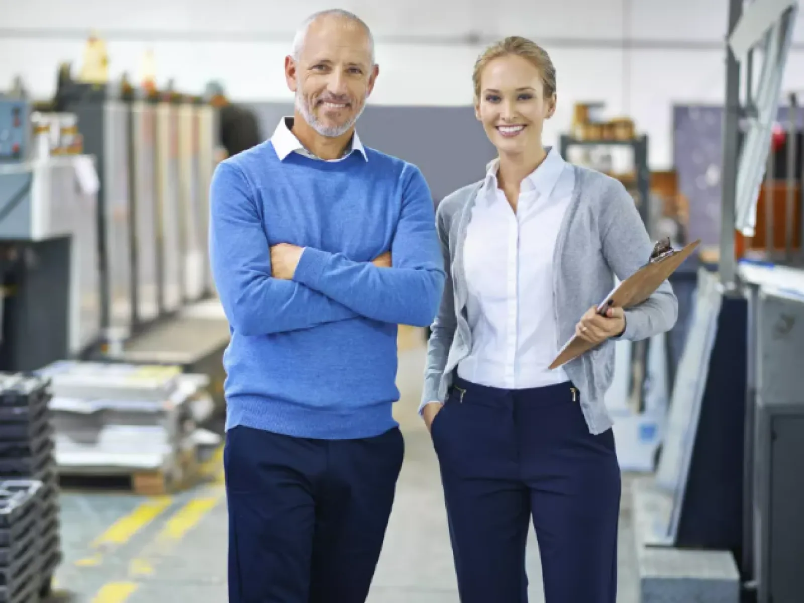 a man and a woman standing in a warehouse