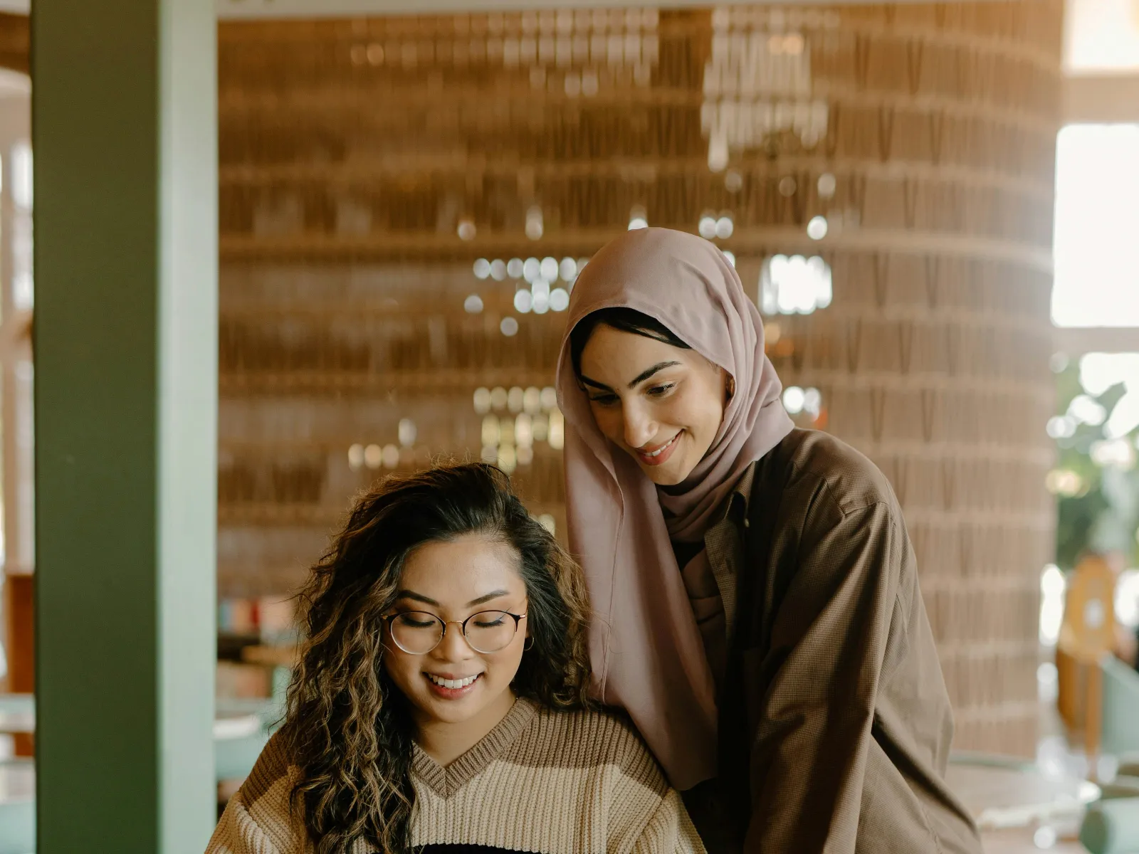 a woman and a girl looking at a laptop
