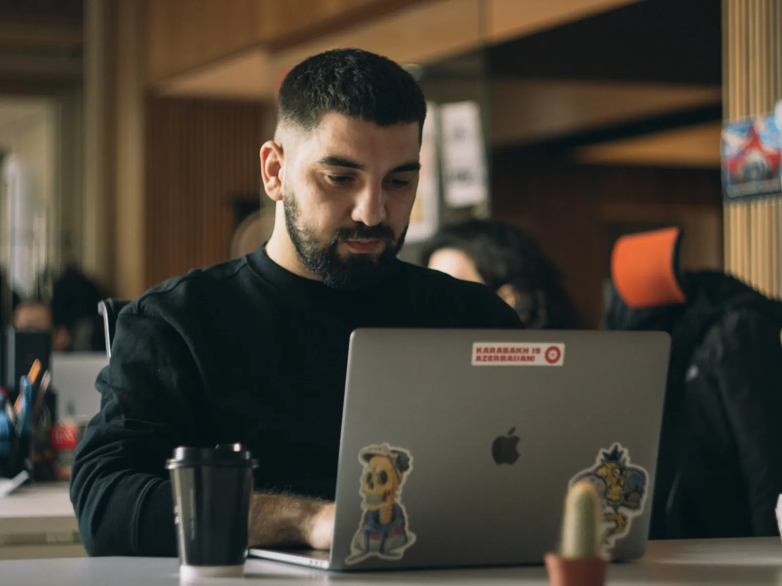 a man sitting at a table with a laptop