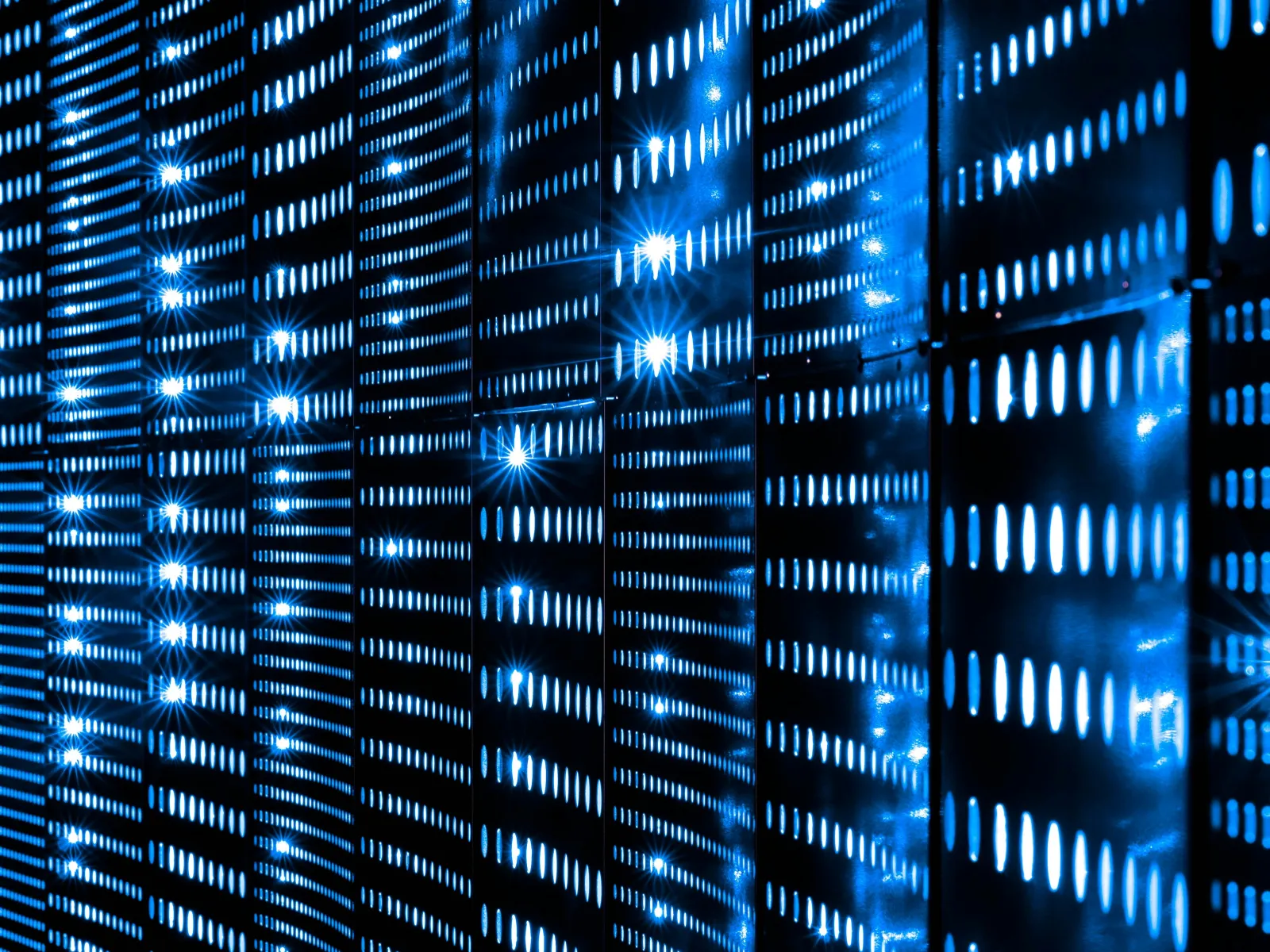 Close-up of illuminated blue server racks with glowing LED lights in a data center environment.