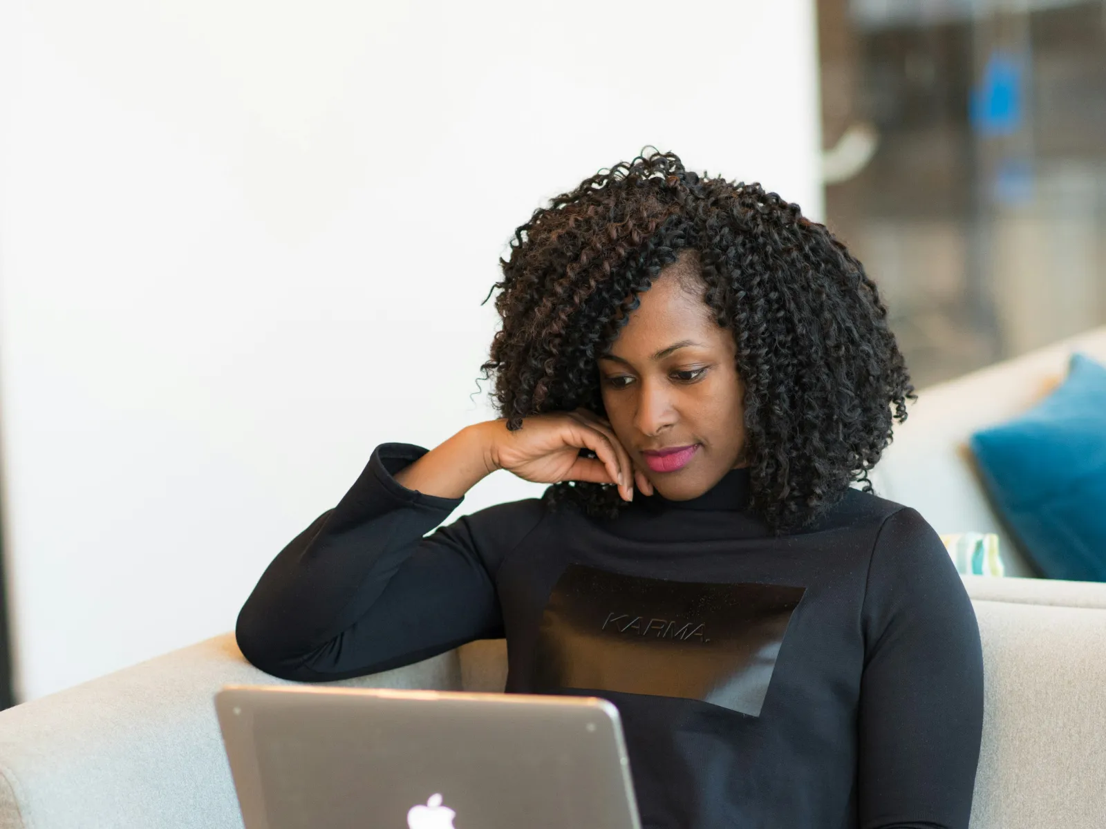 a person sitting on a couch with a laptop