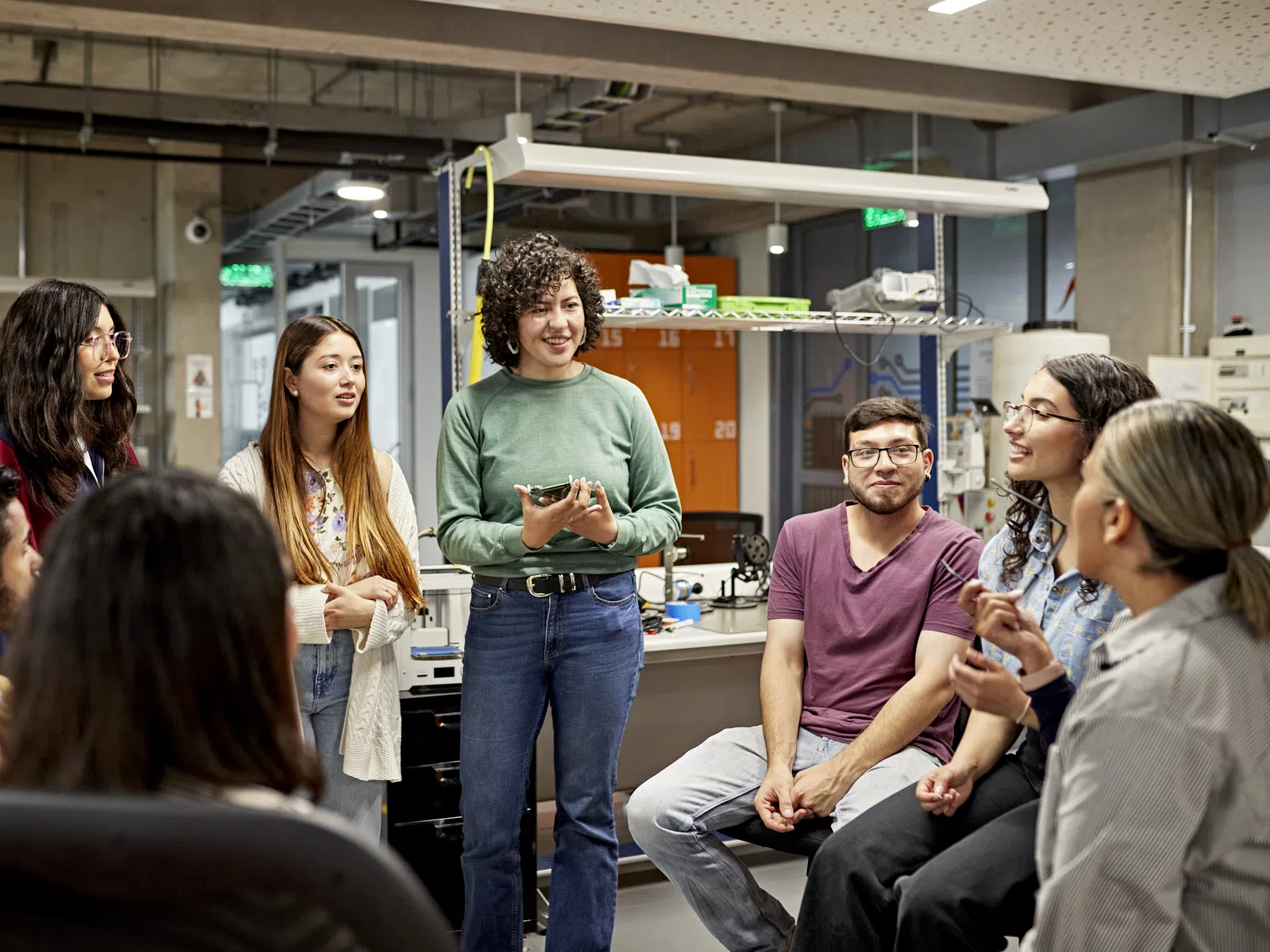 Diverse group of young professionals discussing and collaborating in a modern open office space.