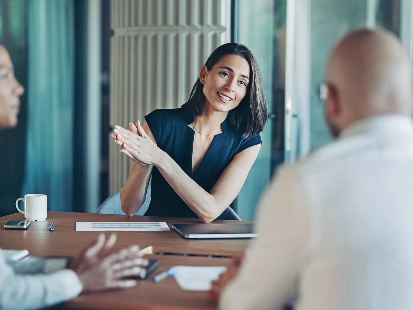 Businesswoman engaging confidently with colleagues during a meeting in a modern office setting