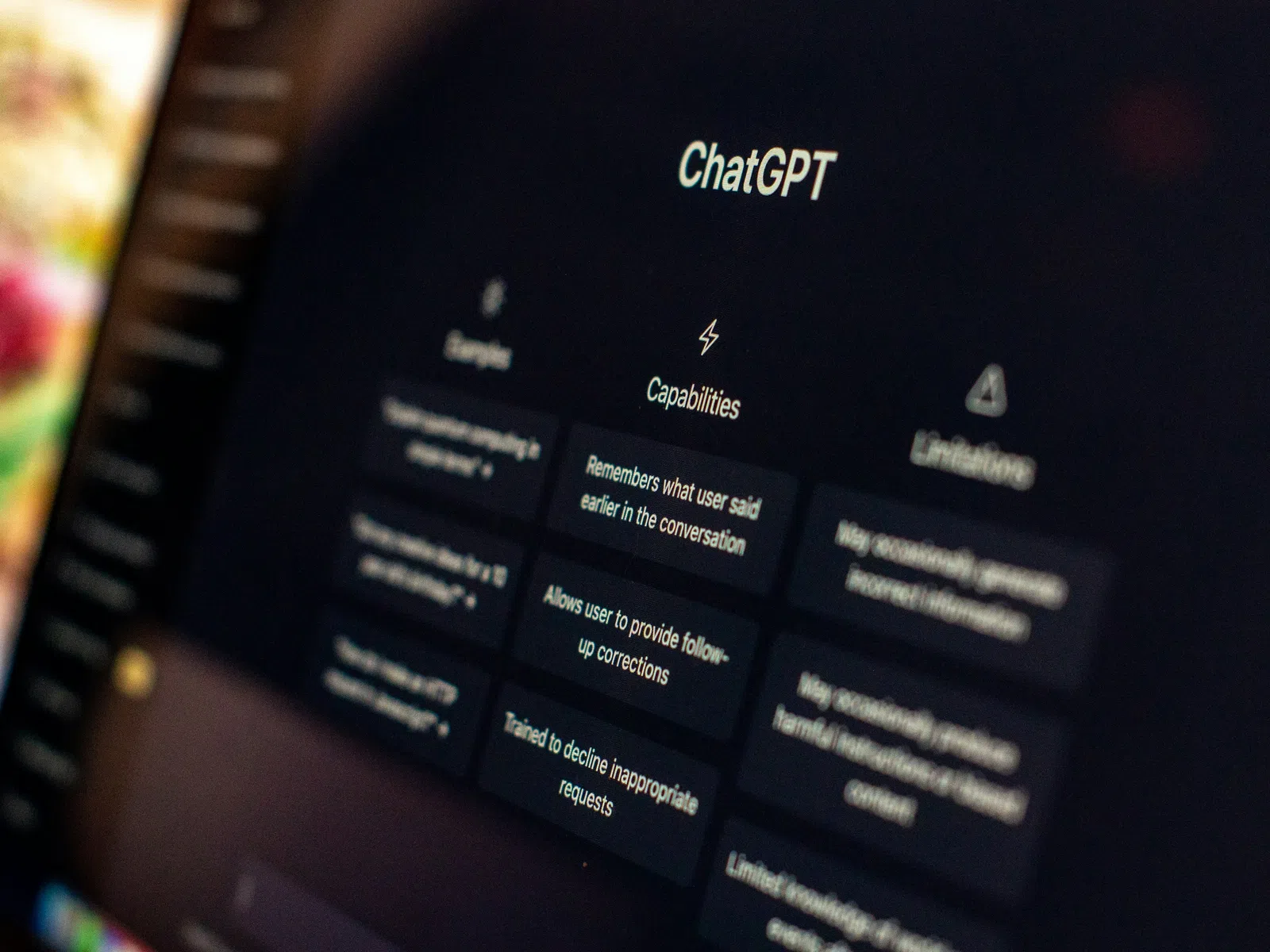 Close-up of ChatGPT interface highlighting examples, capabilities, and limitations on a dark screen.