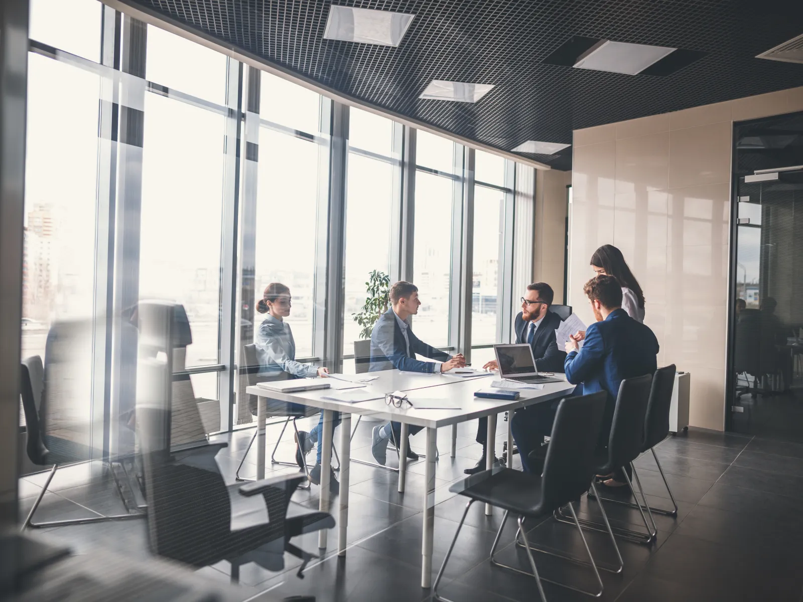 Business team collaborating in a modern office conference room with large windows.