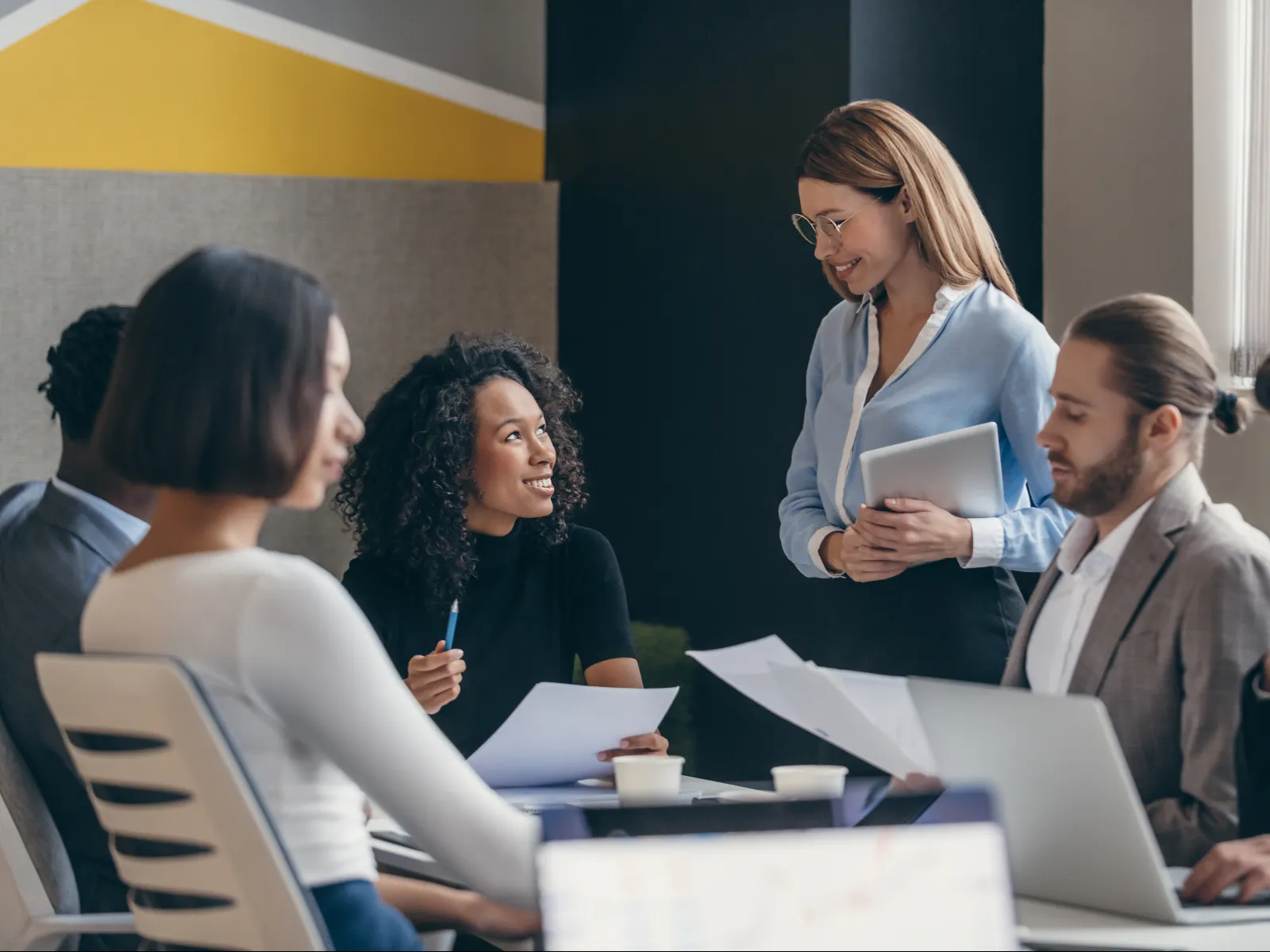 A diverse team engaged in a collaborative meeting at a modern office setting.