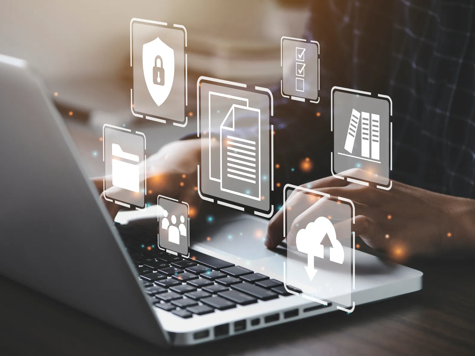 A person using a laptop with digital security icons and documents floating above.