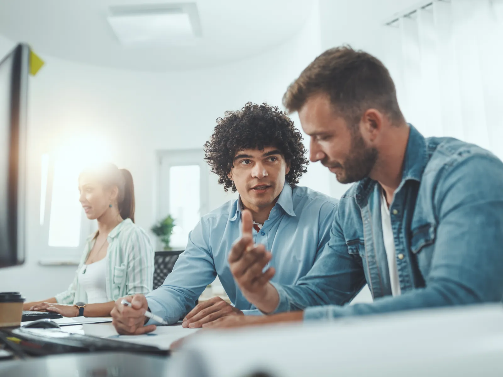 Modern office workspace with diverse professionals collaborating and focused on tasks.