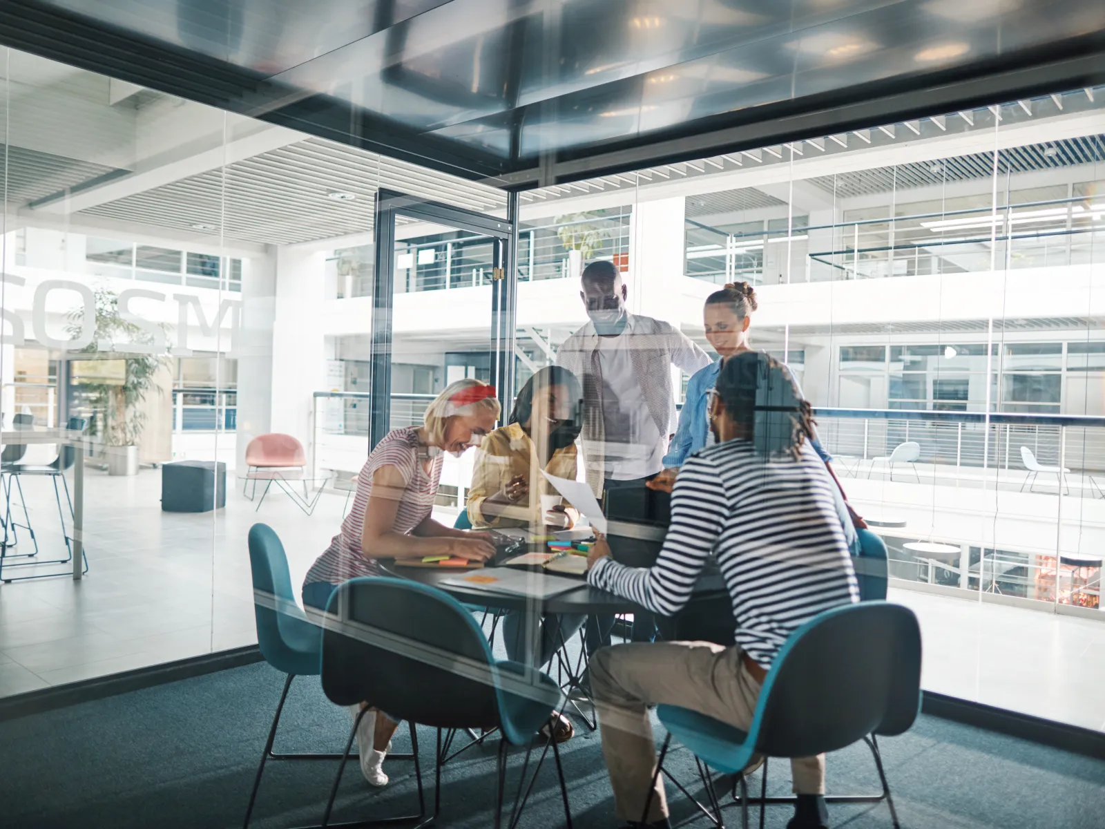 Modern office workspace with diverse professionals collaborating and focused on tasks.